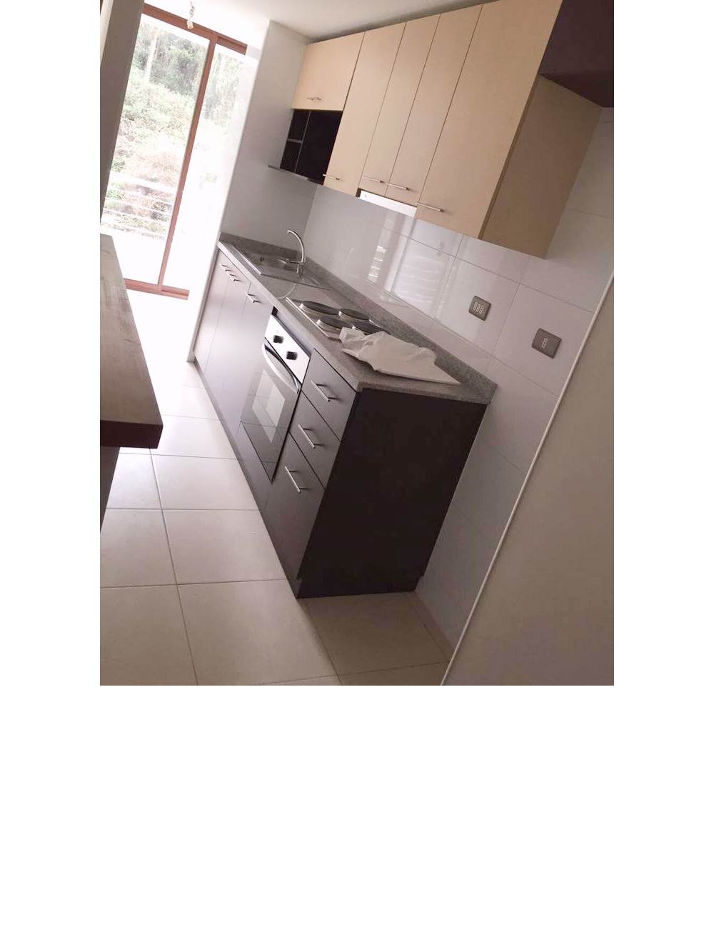 Cocina equipada con muebles modernos, horno y encimera.