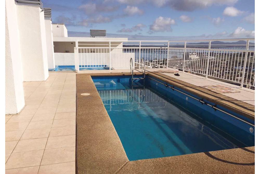 Piscina comunitaria en azotea con vista panorámica.
