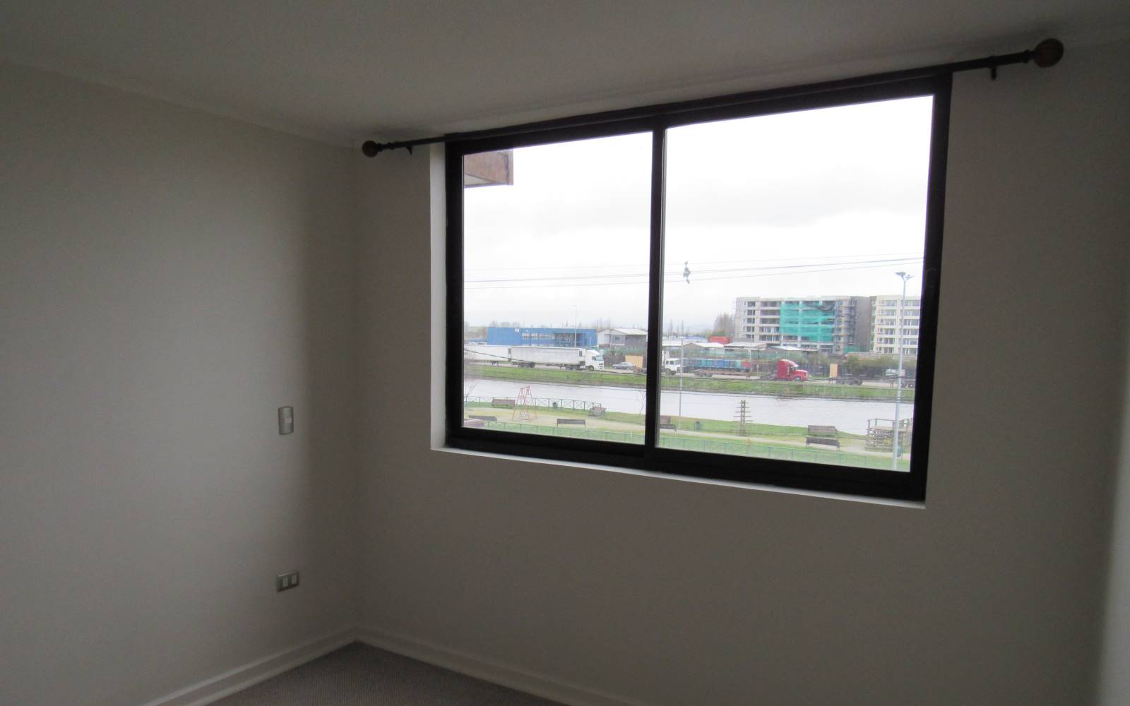 Dormitorio con amplio ventanal y vista al exterior.