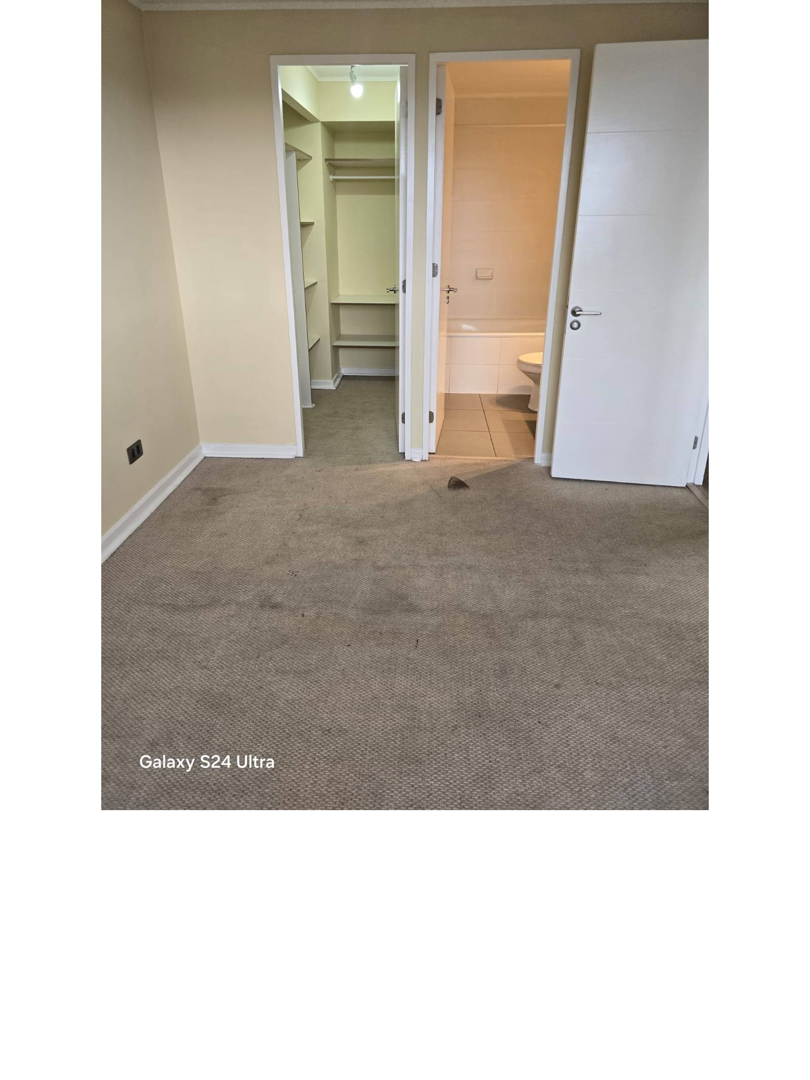 Dormitorio con accesos directos a walk-in closet y baño en suite.