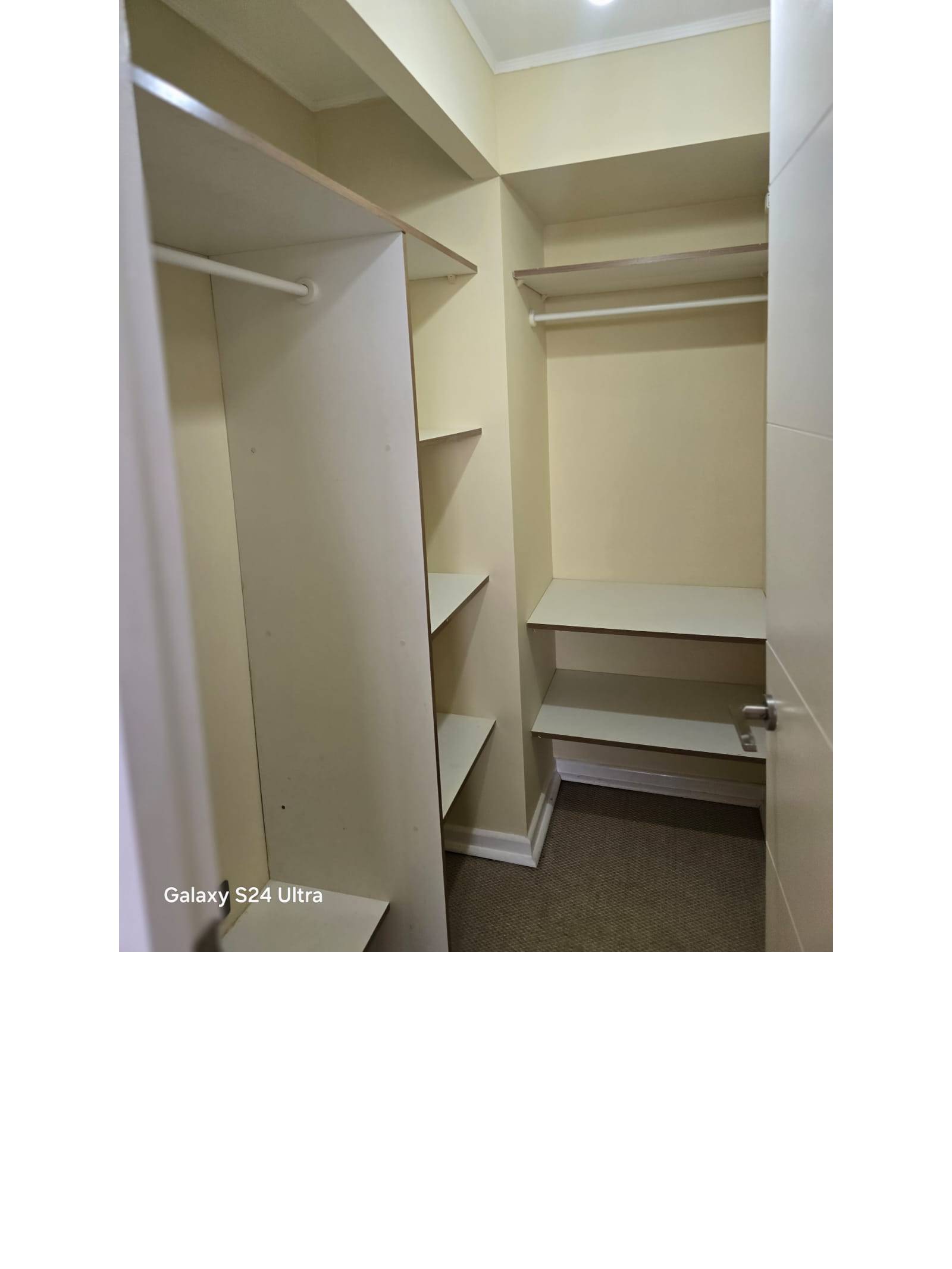 Walk-in closet con repisas y barras para colgar ropa.