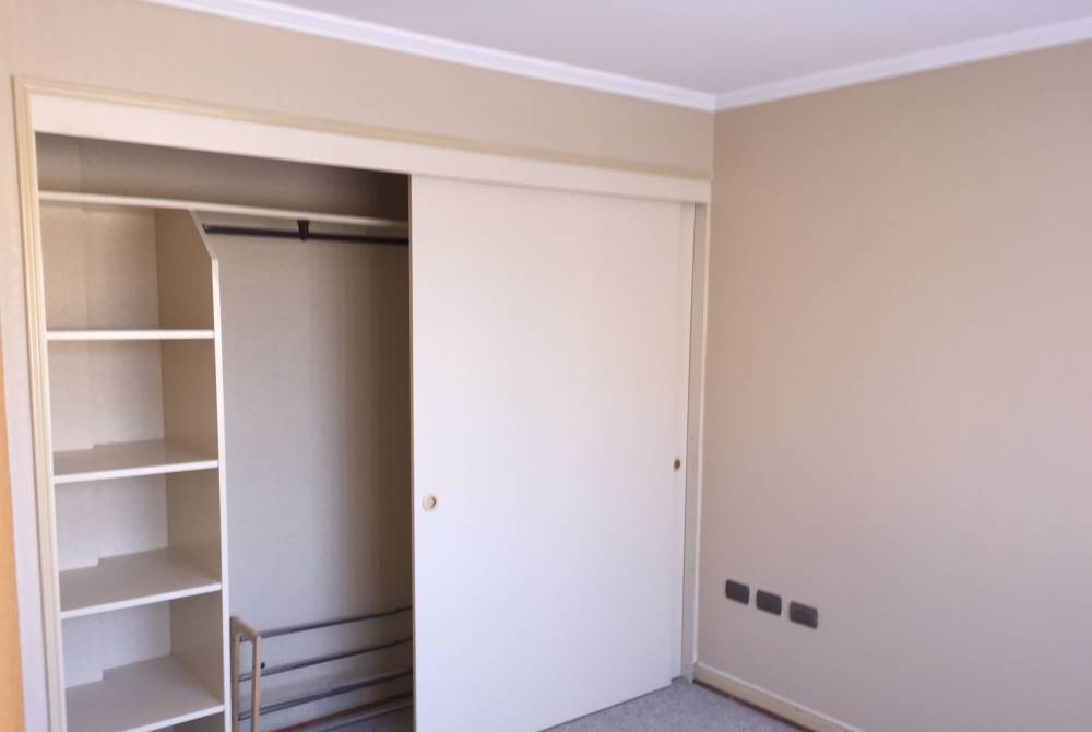 Dormitorio con clóset empotrado de puertas correderas.