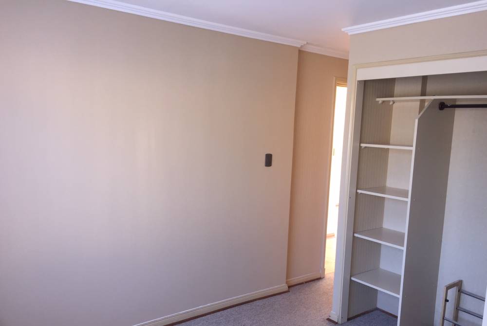 Habitación vacía con clóset y acceso a pasillo.