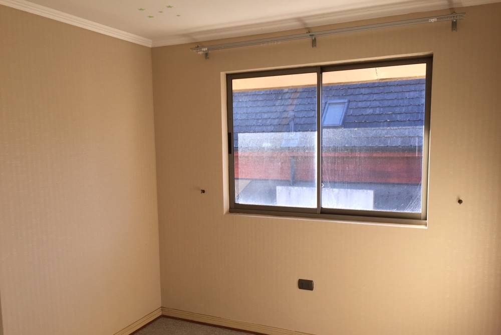 Habitación vacía con ventana de aluminio.