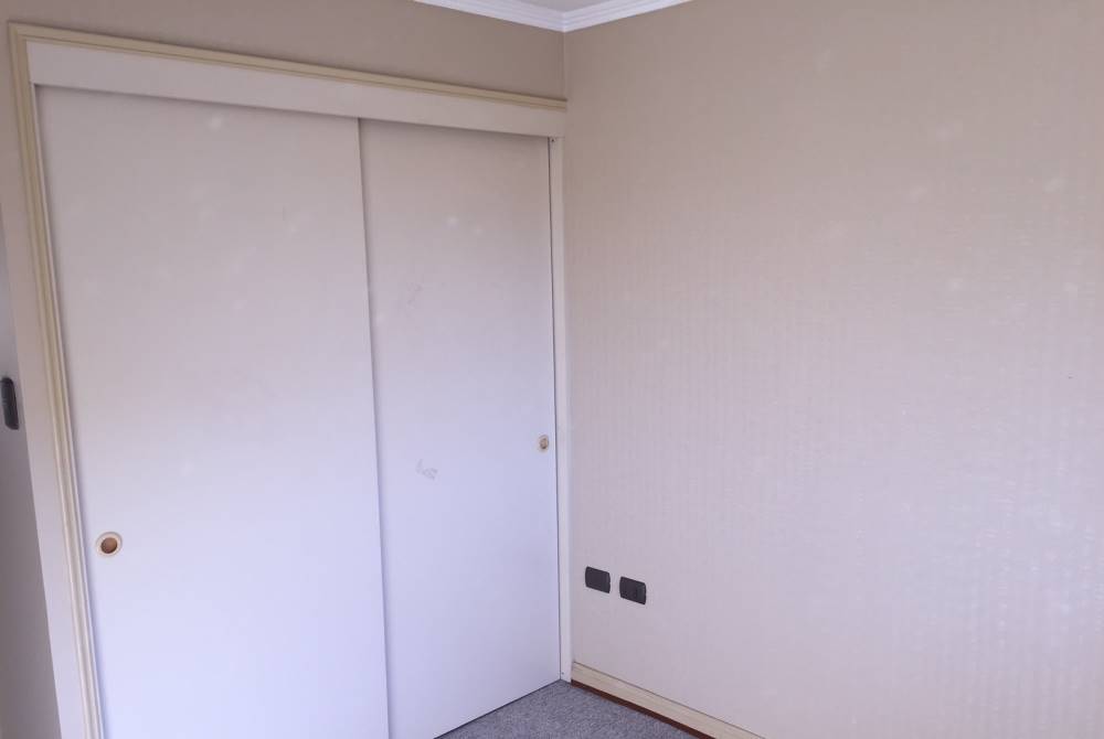 Clóset empotrado con puertas correderas blancas.