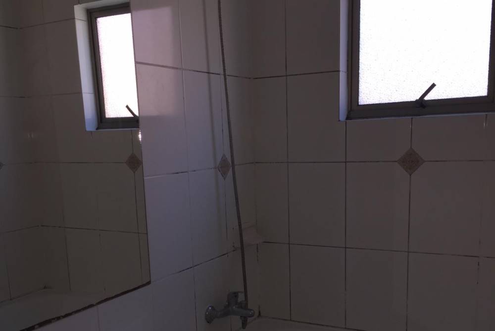 Ducha con cerámica en paredes y ventanas de ventilación.