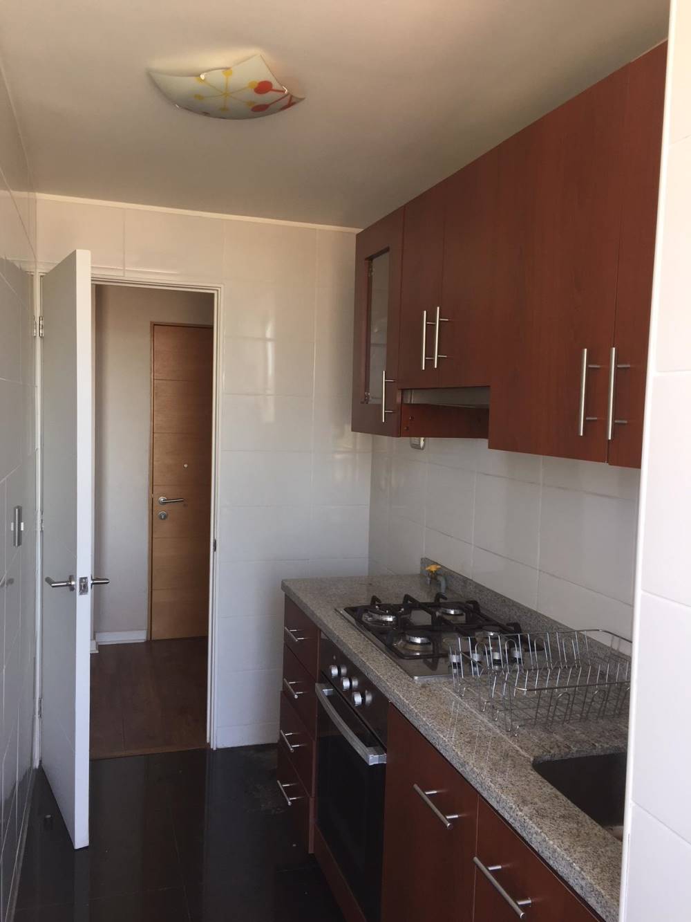 Cocina equipada con encimera a gas, horno y muebles empotrados