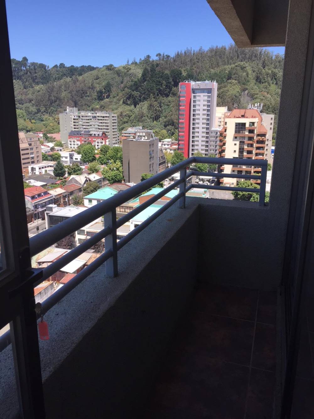 Balcón con baranda metálica y vista despejada a la ciudad