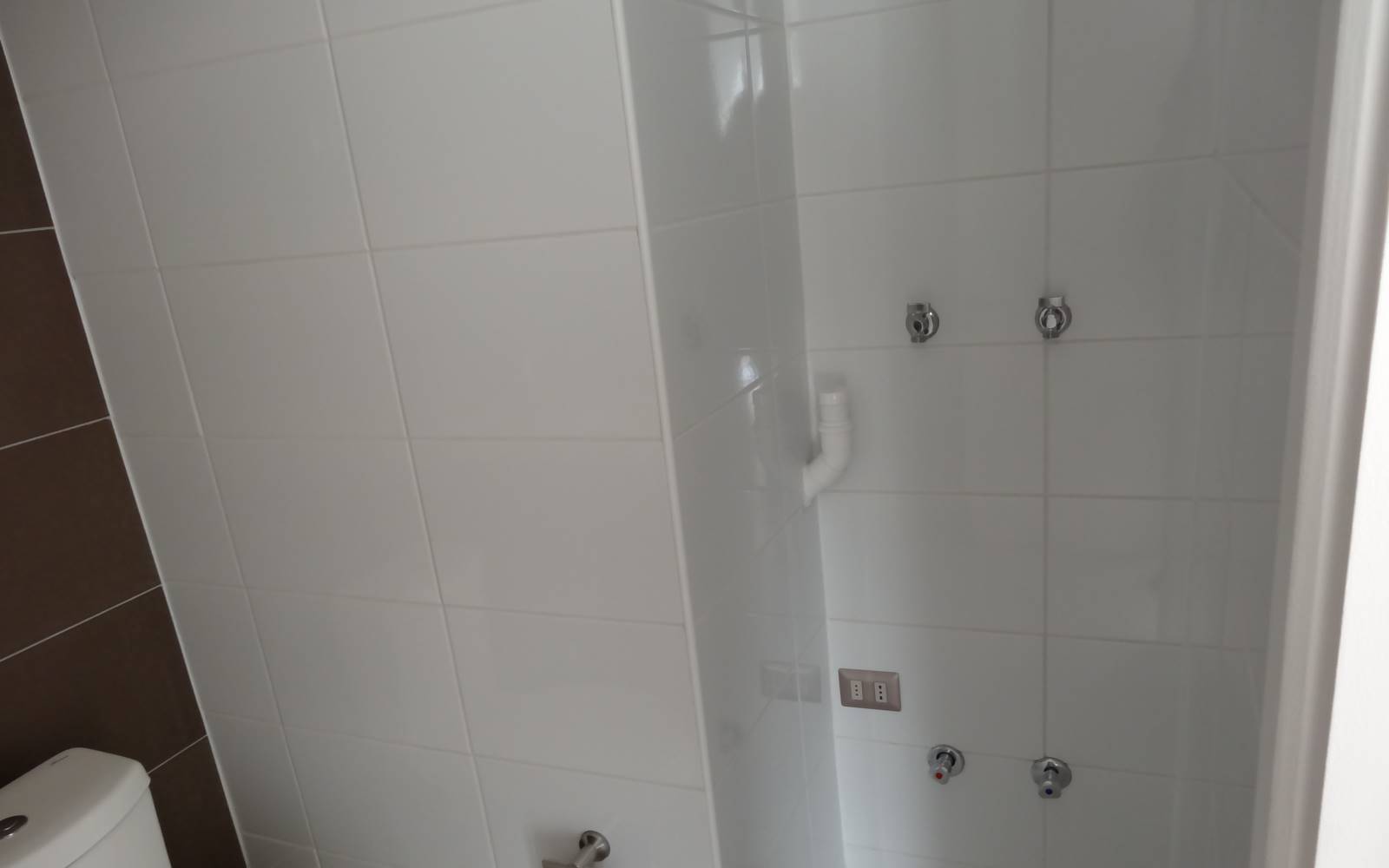 Sector de ducha con cerámicas blancas en pared.
