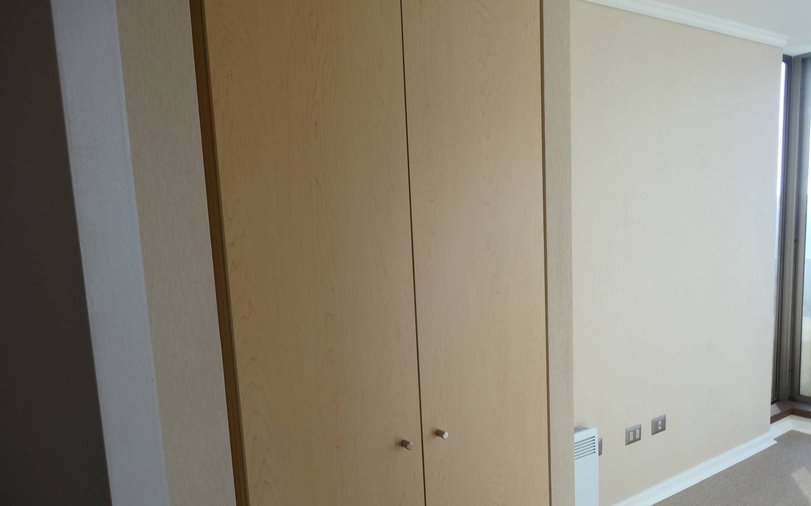 Clóset integrado de madera en habitación despejada.