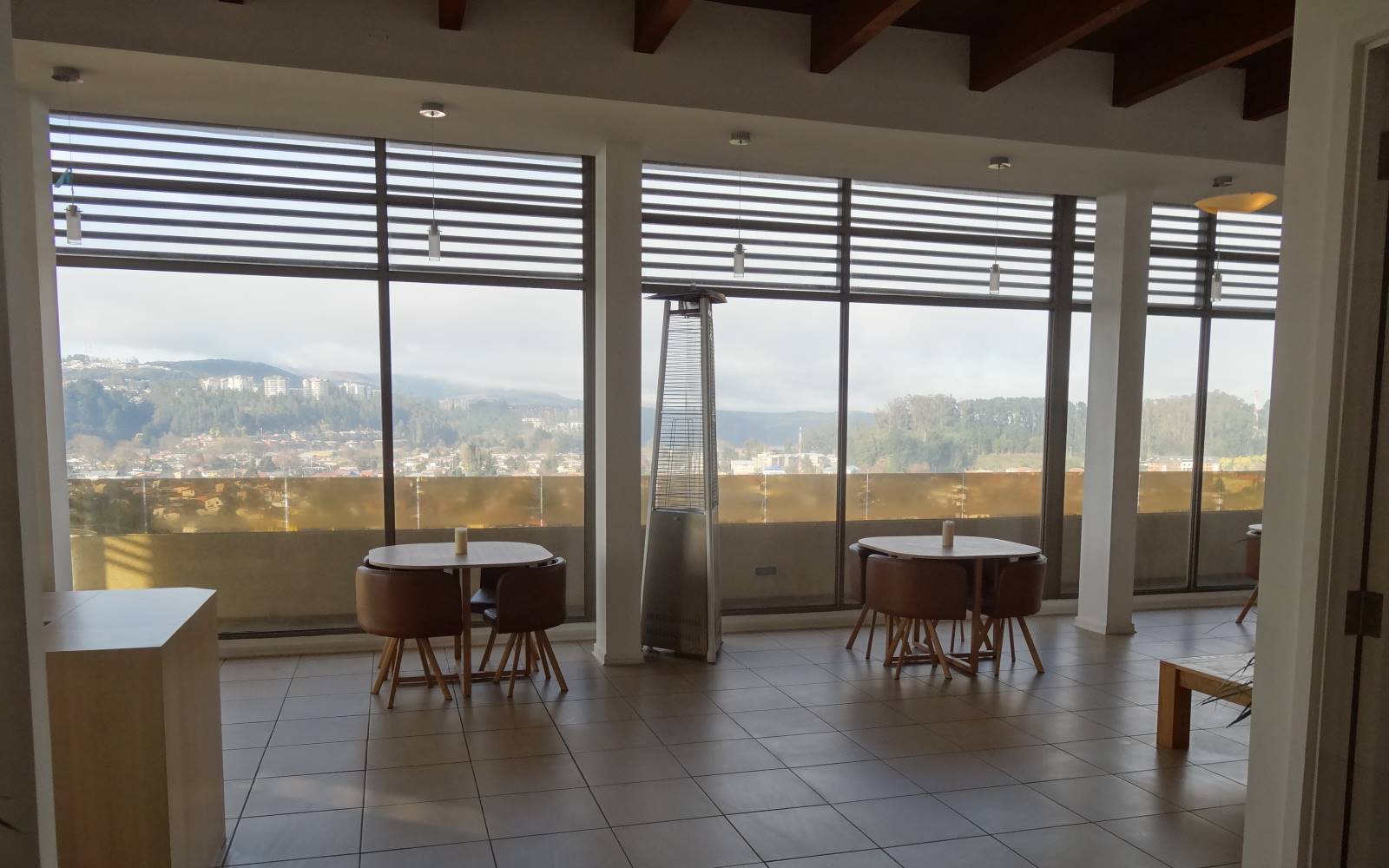 Sala común o quincho con mesas y amplios ventanales.
