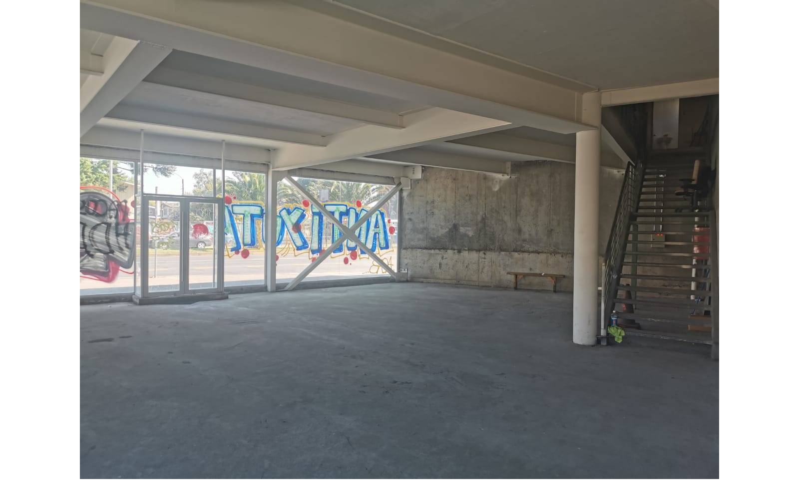 Planta libre con muro de hormigón y escalera metálica