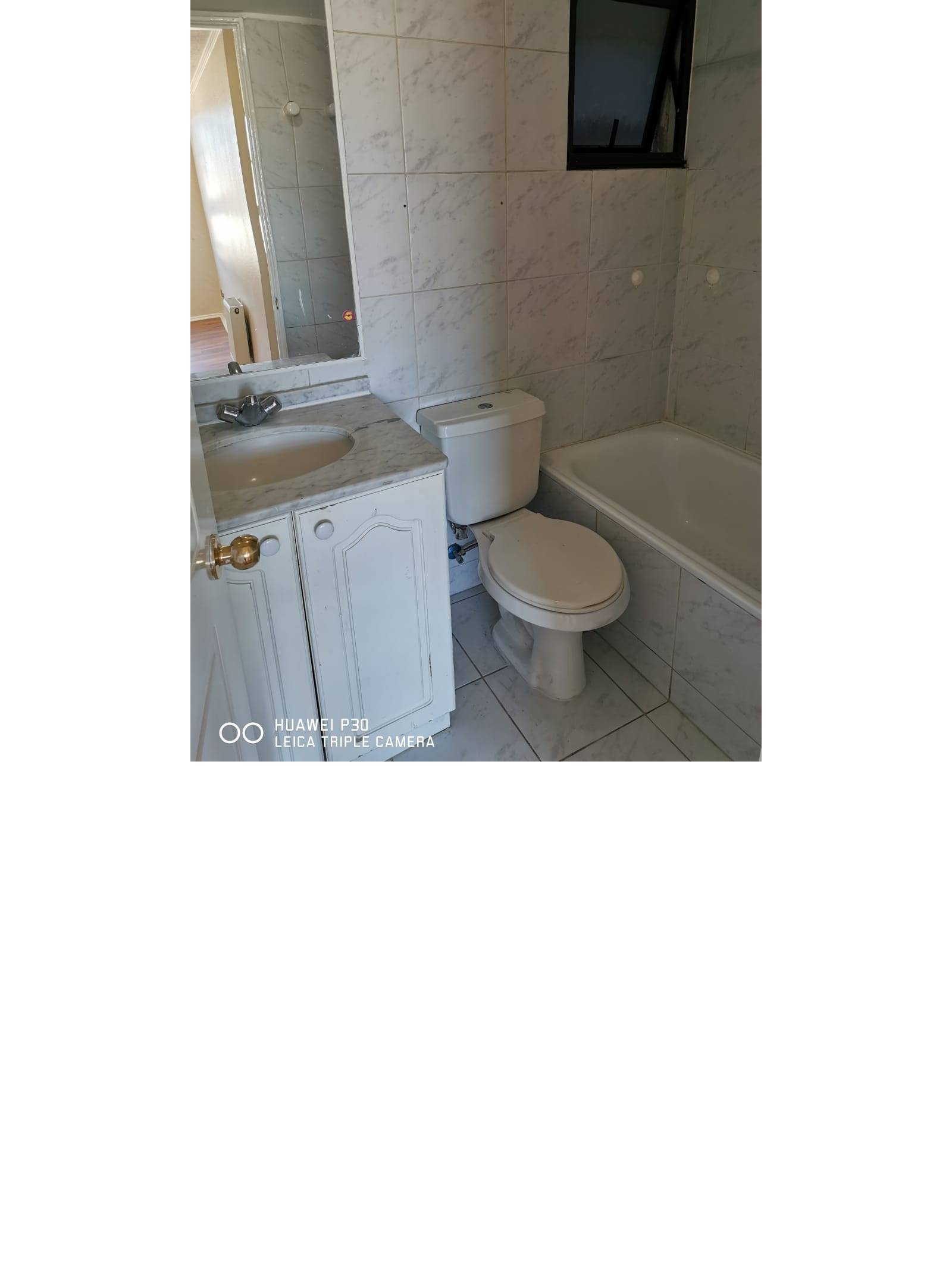 Baño con tina y vanitorio con cubierta de mármol