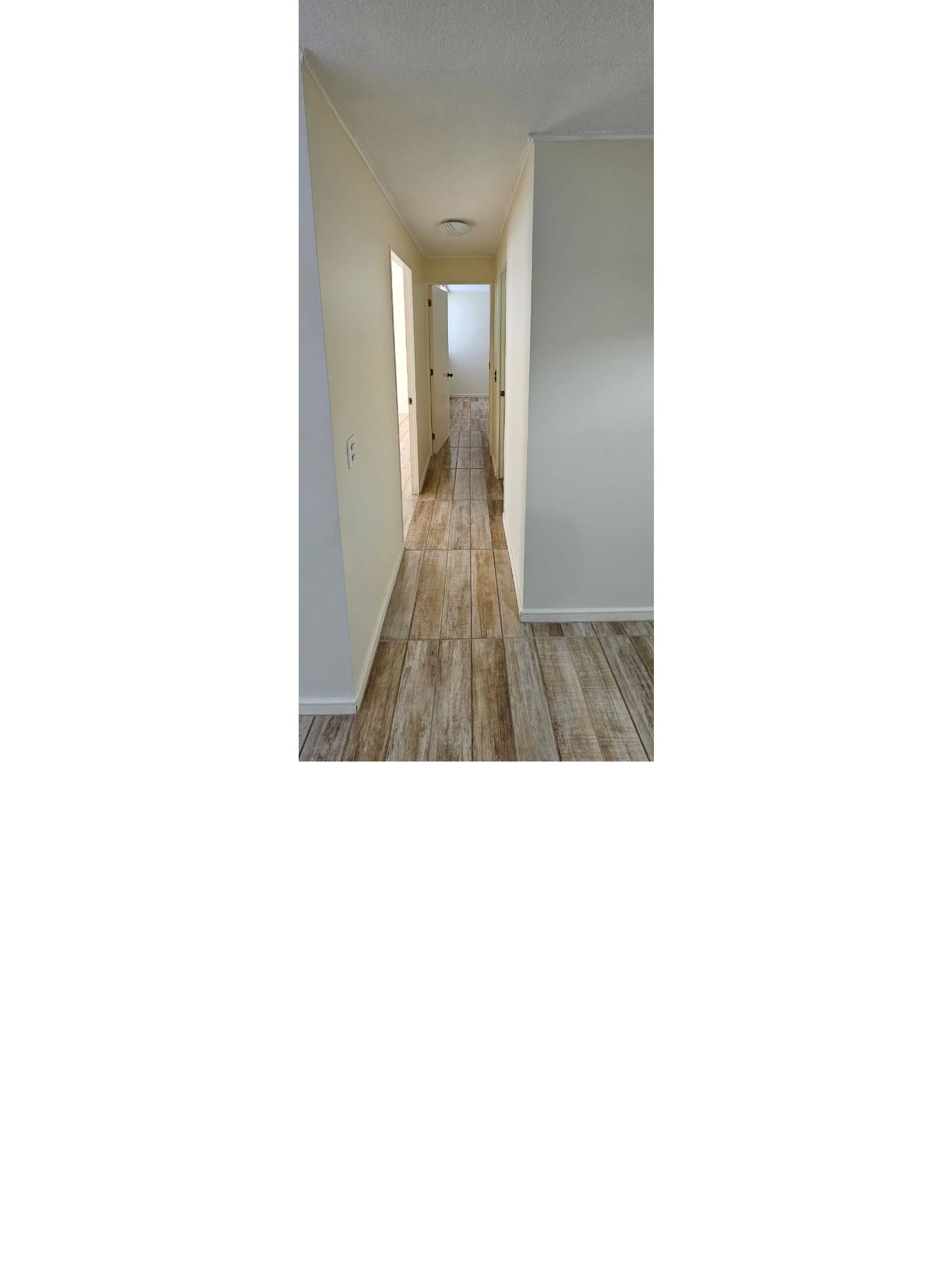 Pasillo interior de distribución hacia habitaciones con piso cerámico
