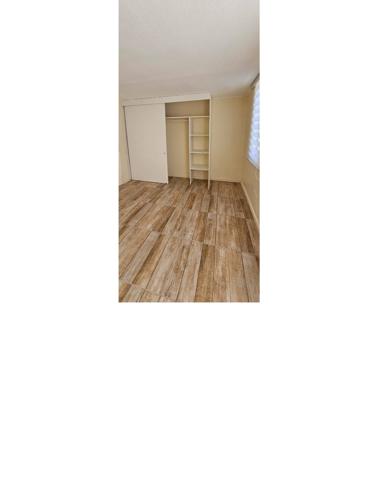 Dormitorio con clóset abierto mostrando repisas y barra
