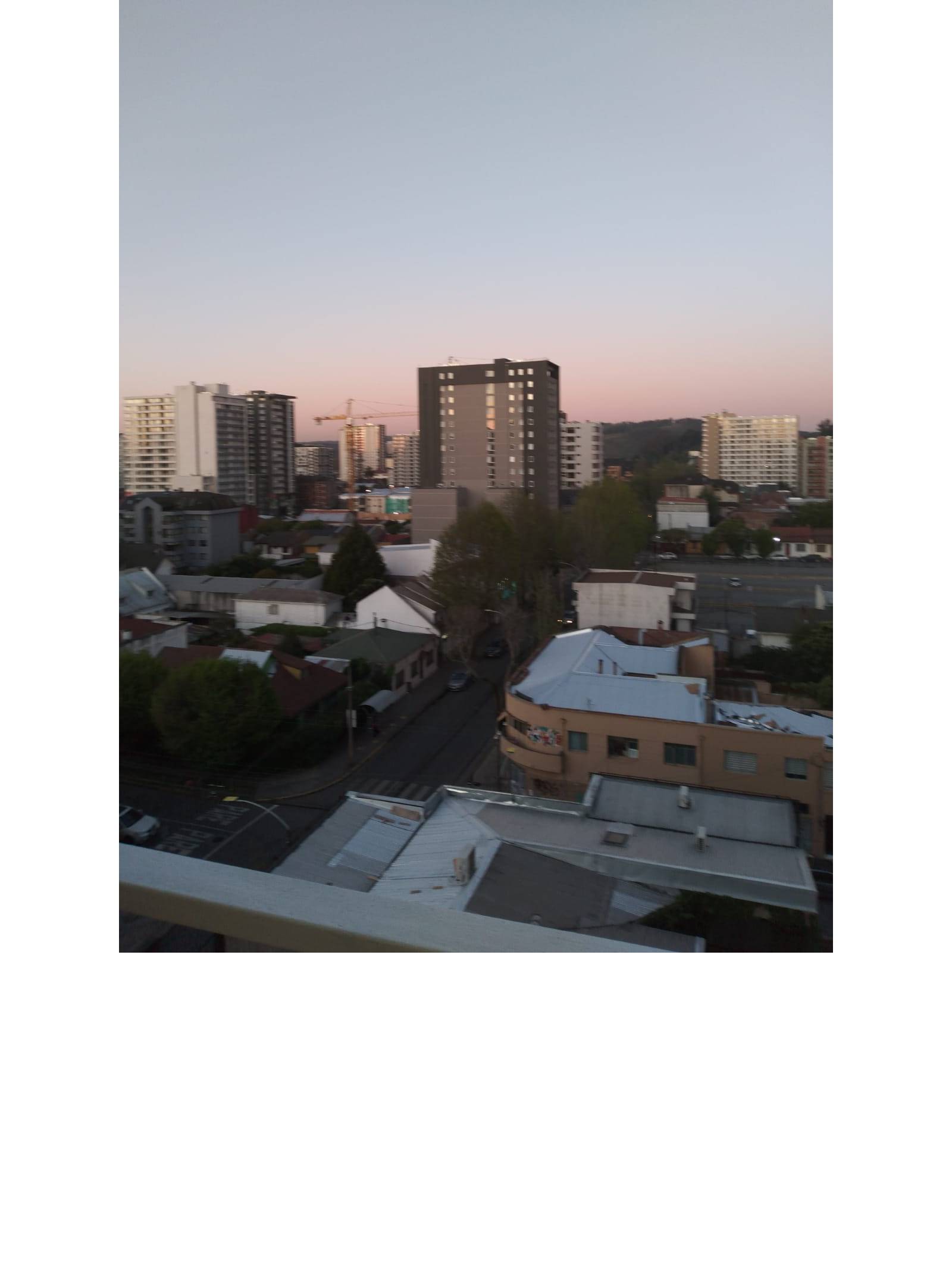 Vista panorámica urbana al atardecer desde departamento