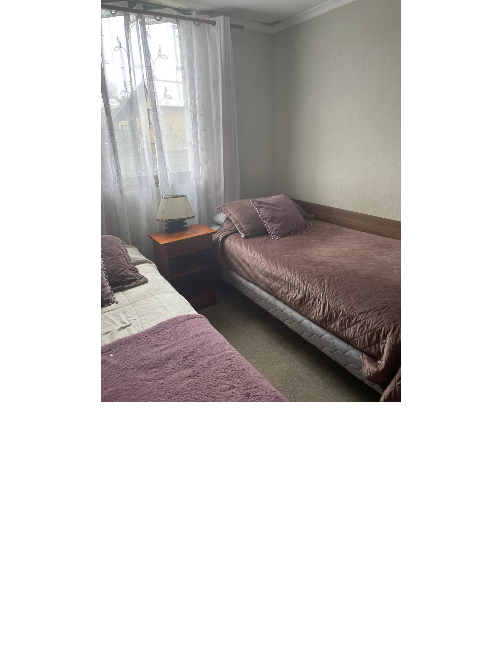 Dormitorio con dos camas individuales y ventana