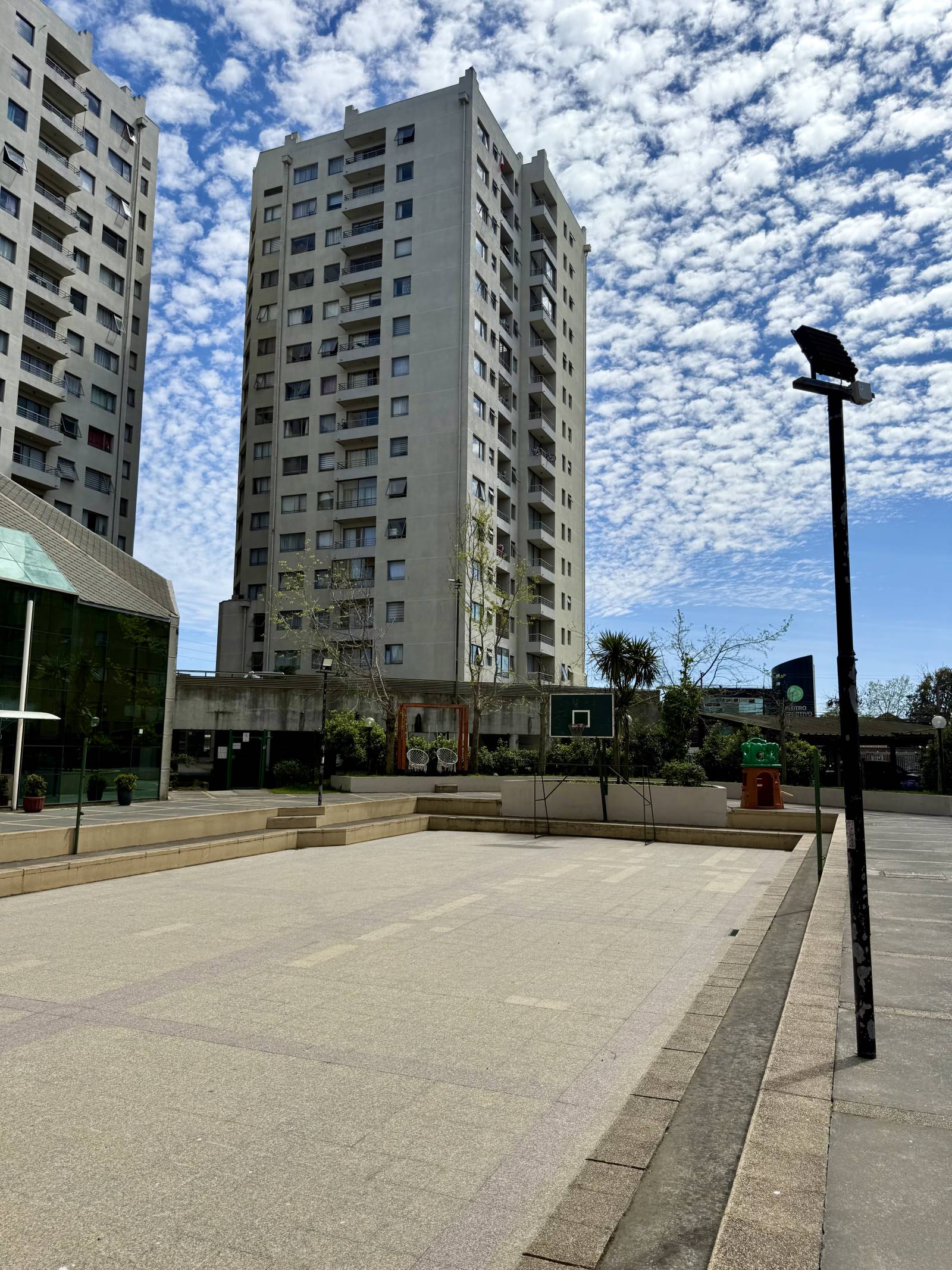 Plaza interior y multicancha con edificios residenciales de fondo.