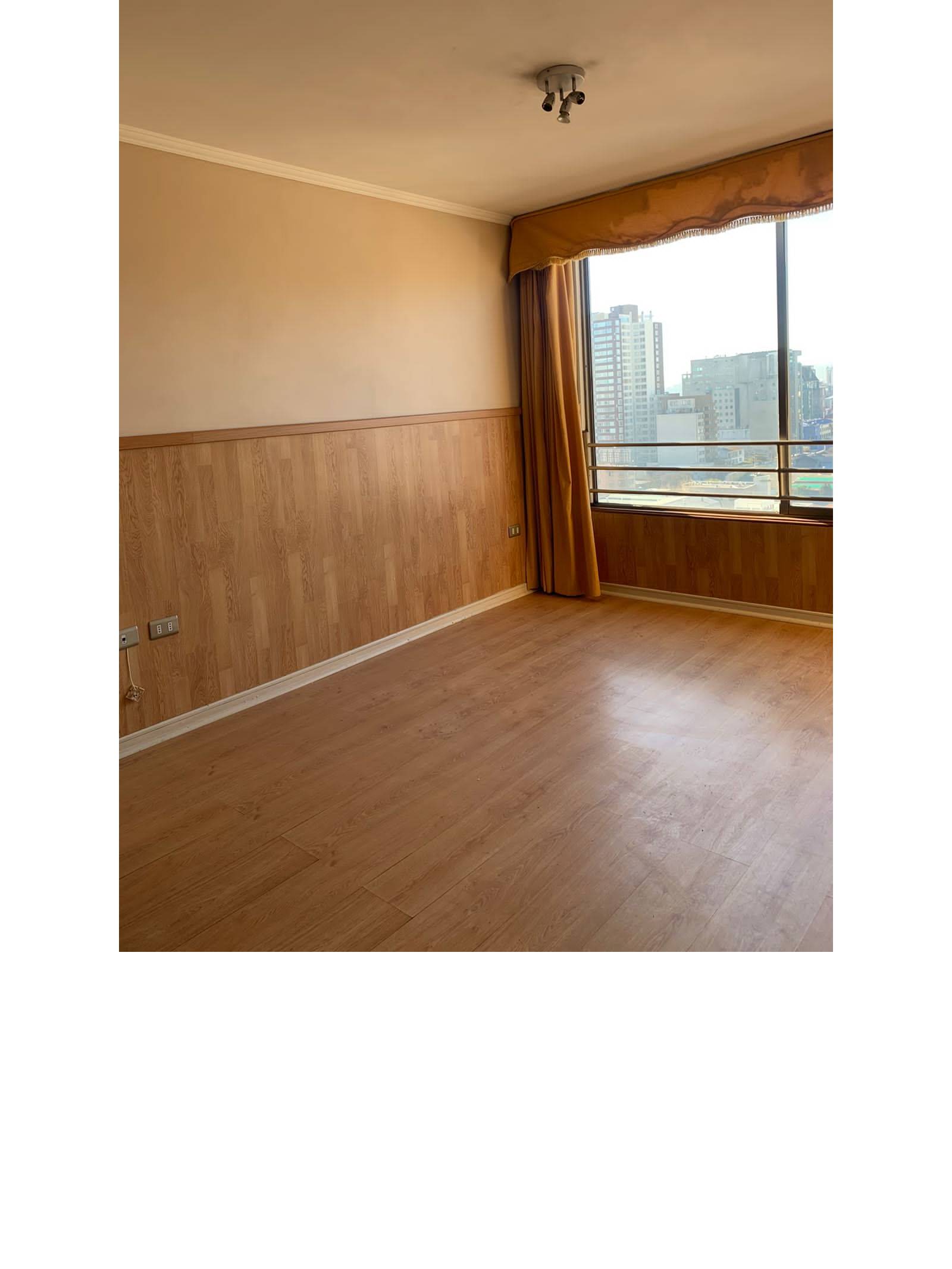 Dormitorio con zócalo de madera y amplio ventanal con vista