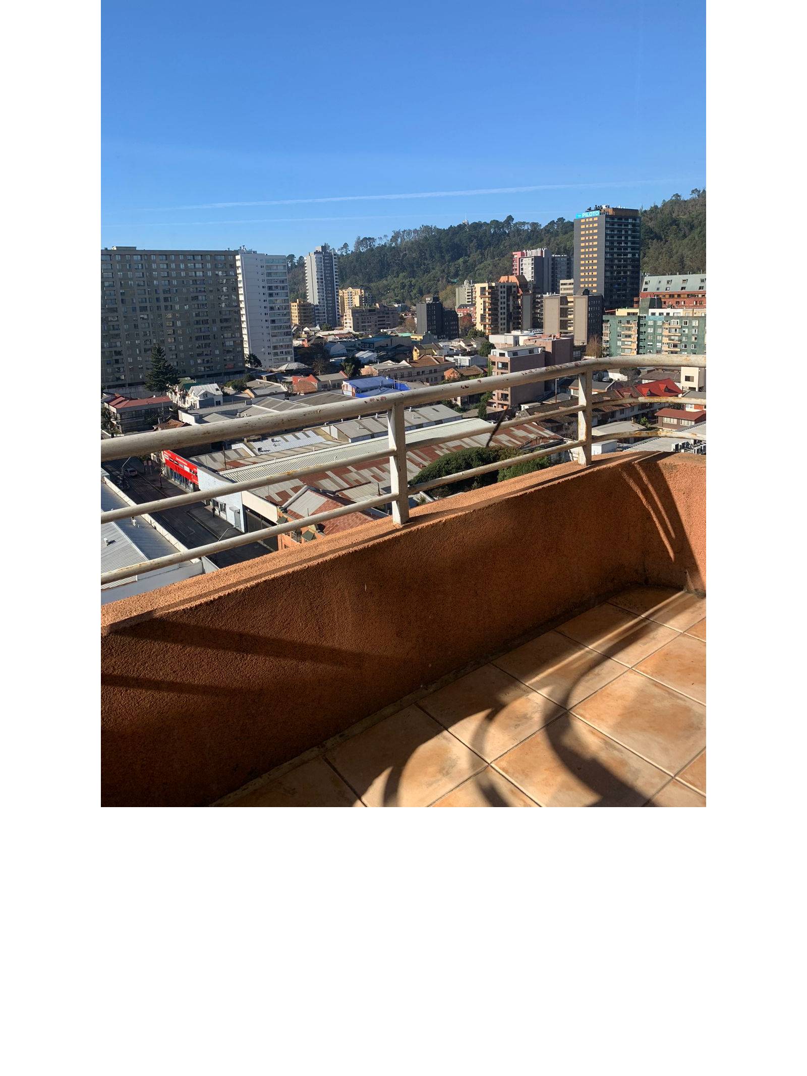 Balcón con baranda metálica y despejada vista panorámica urbana