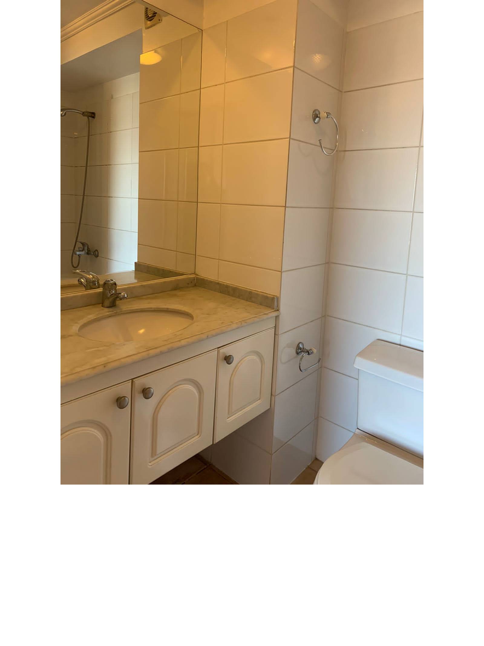 Vanitorio de mármol con mueble en baño azulejado