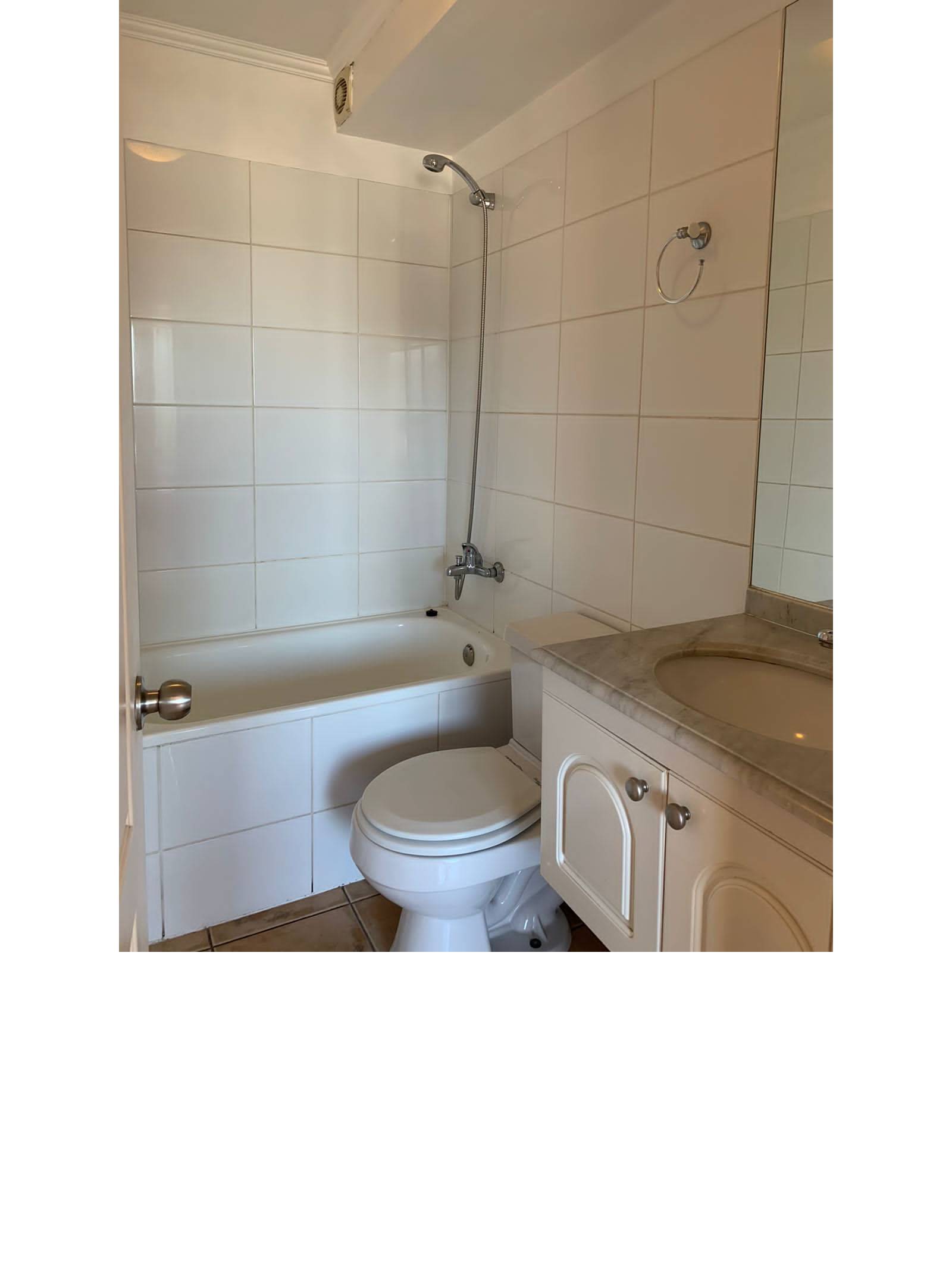 Baño completo con tina, inodoro y vanitorio blanco