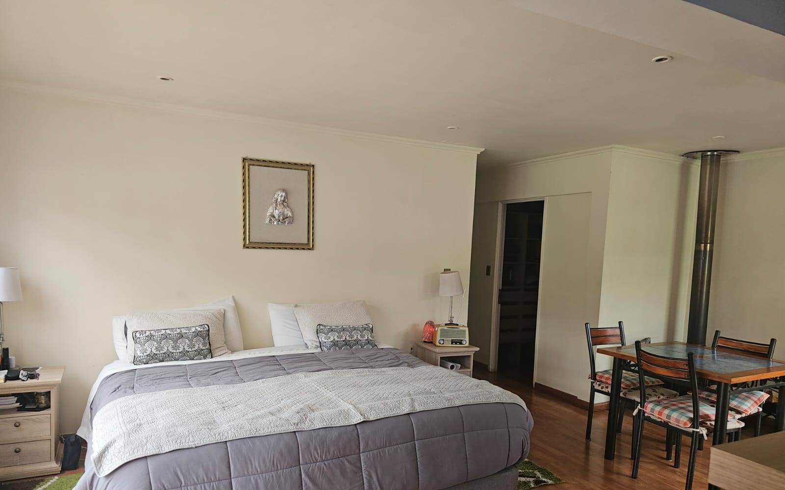 Dormitorio principal amplio con cama king y zona de comedor.