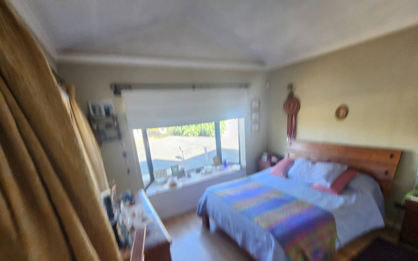 Dormitorio con cama matrimonial y ventana mirador desenfocada