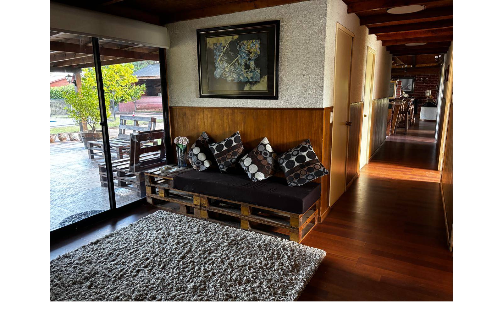 Pasillo de distribución con sillón de palets y piso flotante.