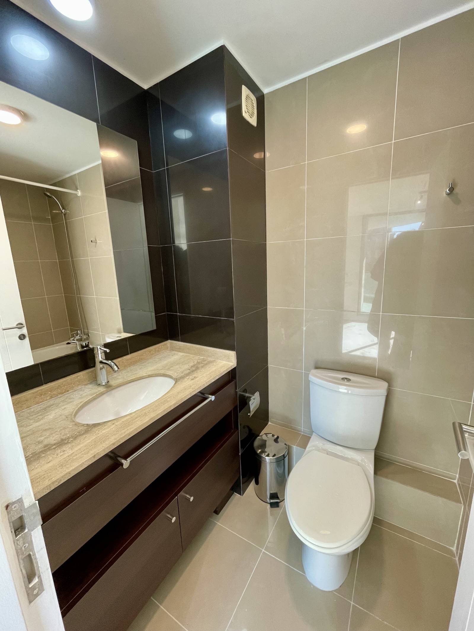 Baño moderno con vanitorio de mármol y muros cerámicos