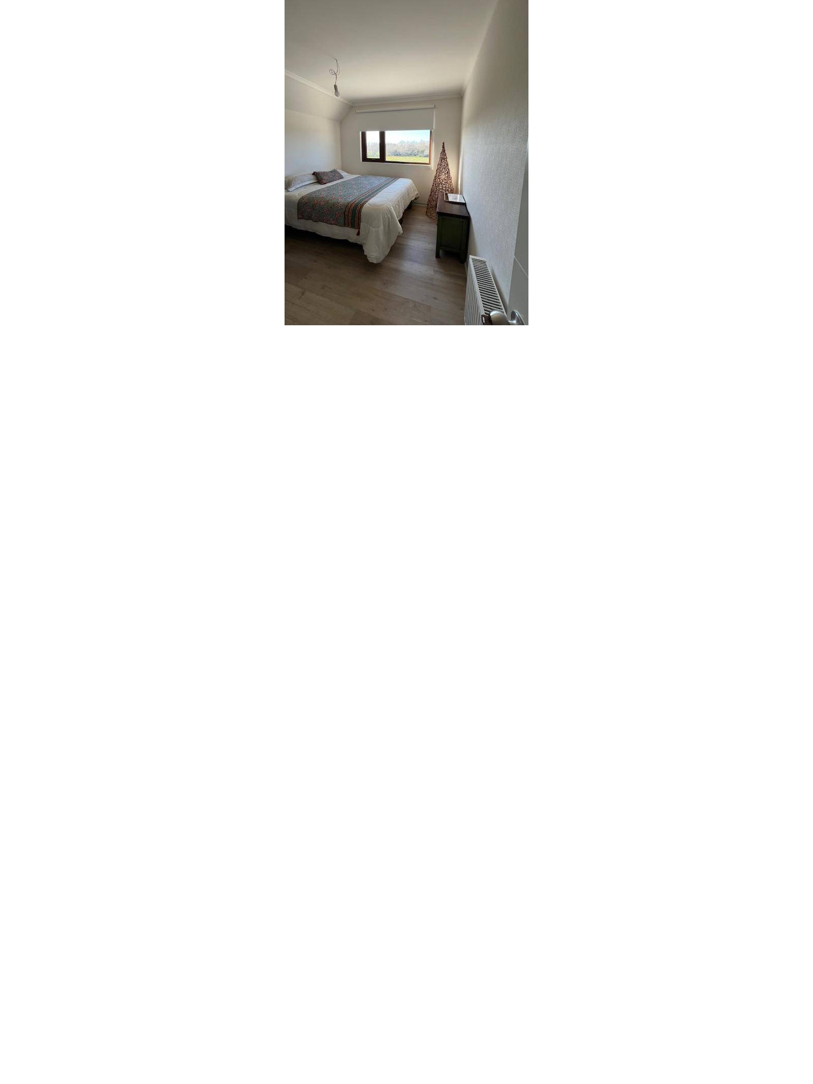 Dormitorio con cama de dos plazas y ventana al fondo