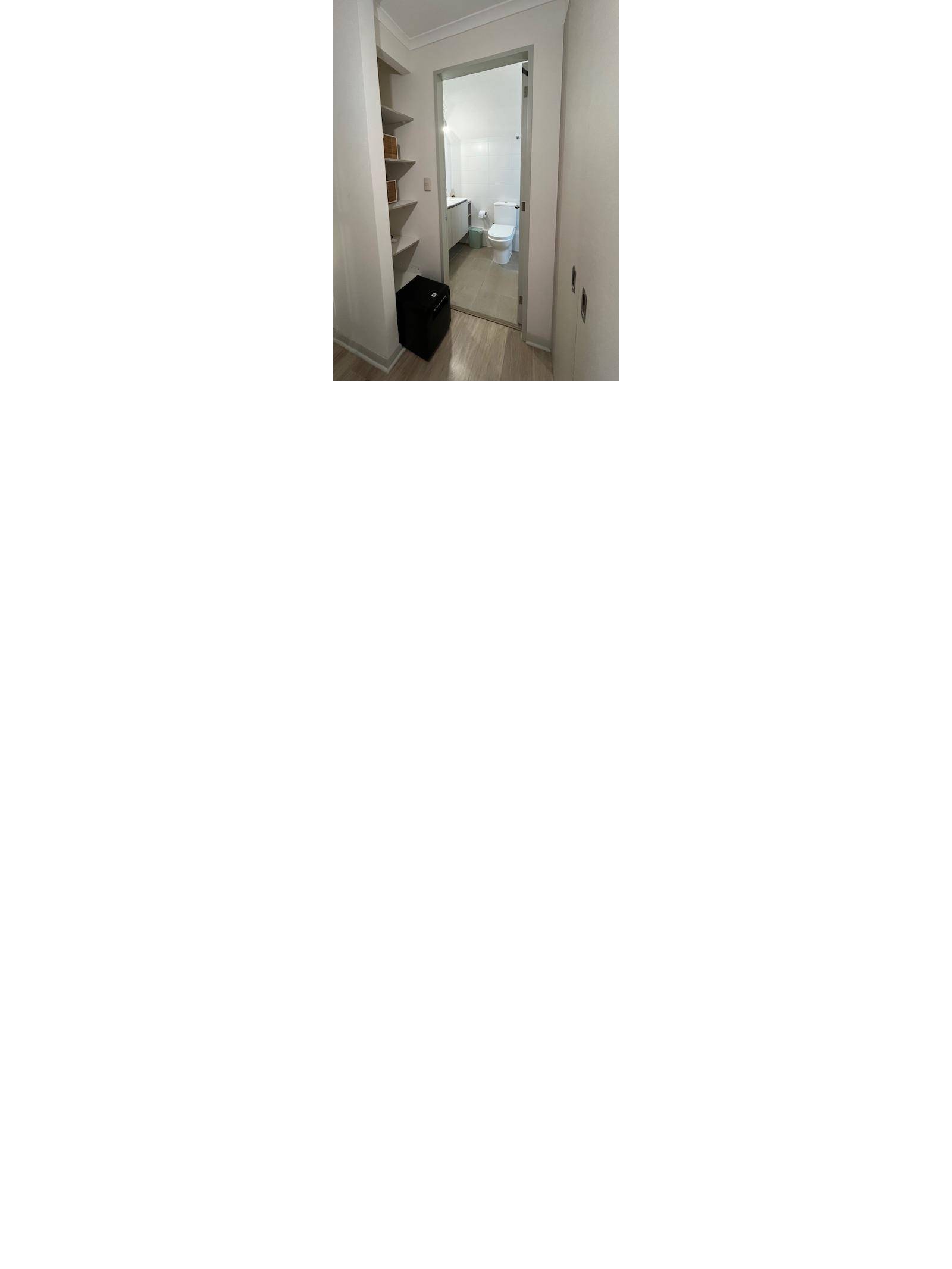Pasillo hacia baño completo con repisas organizadoras