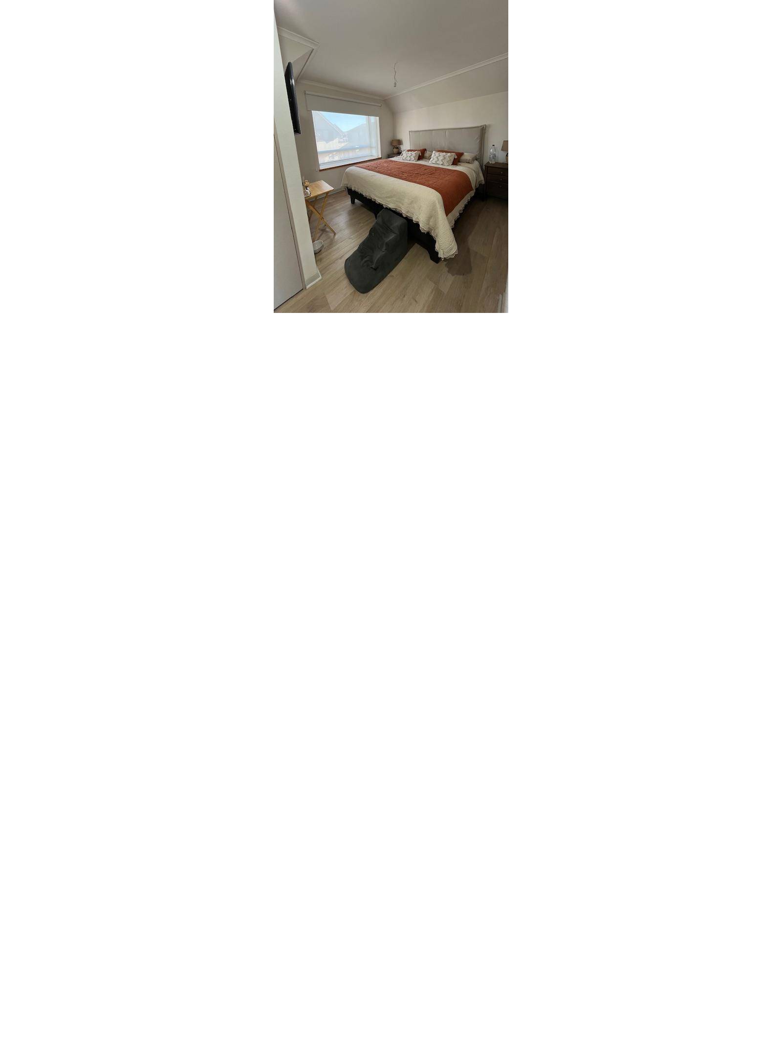 Dormitorio principal con cama matrimonial y respaldo tapizado