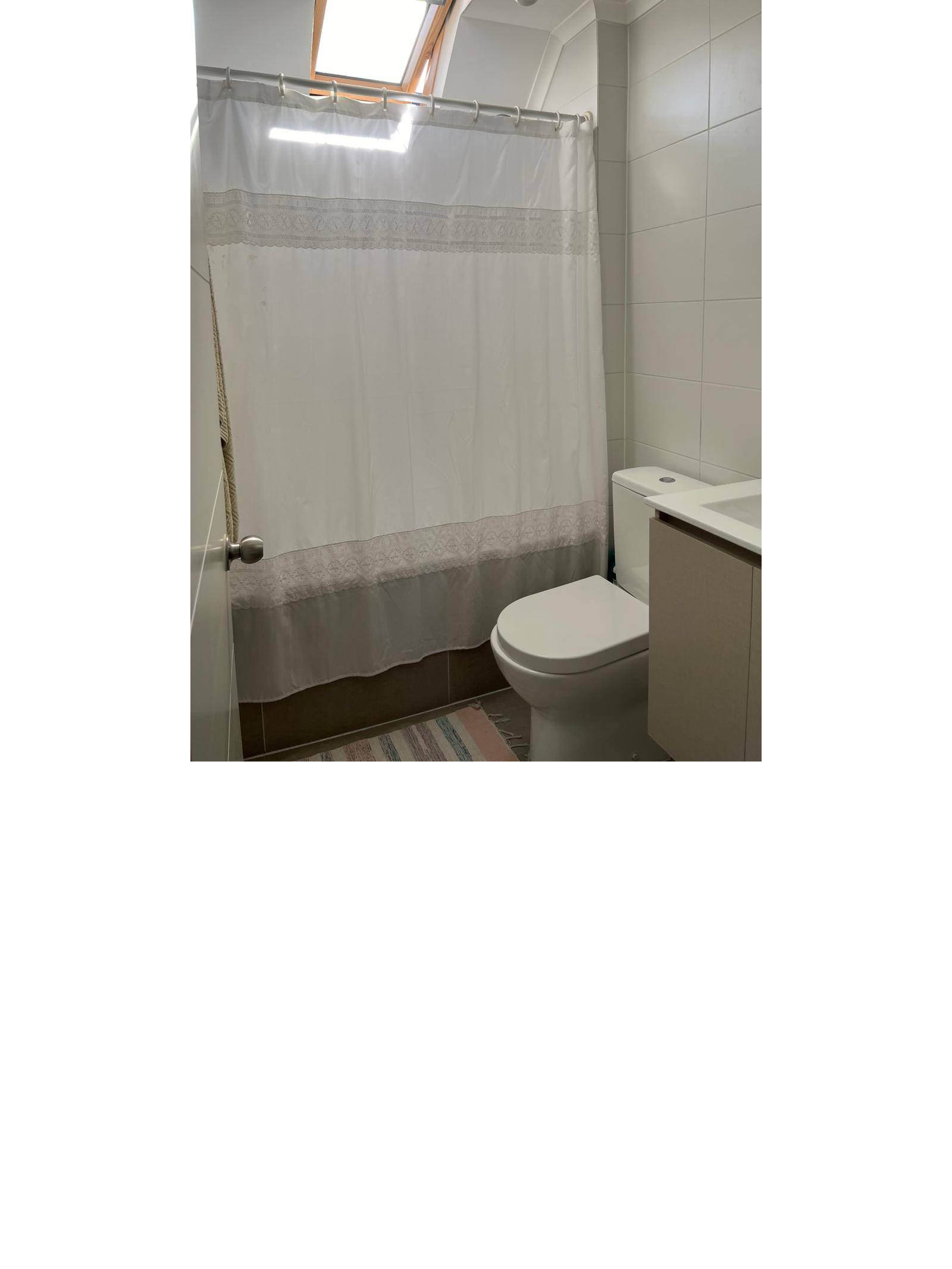 Baño secundario con tina y tragaluz en el techo