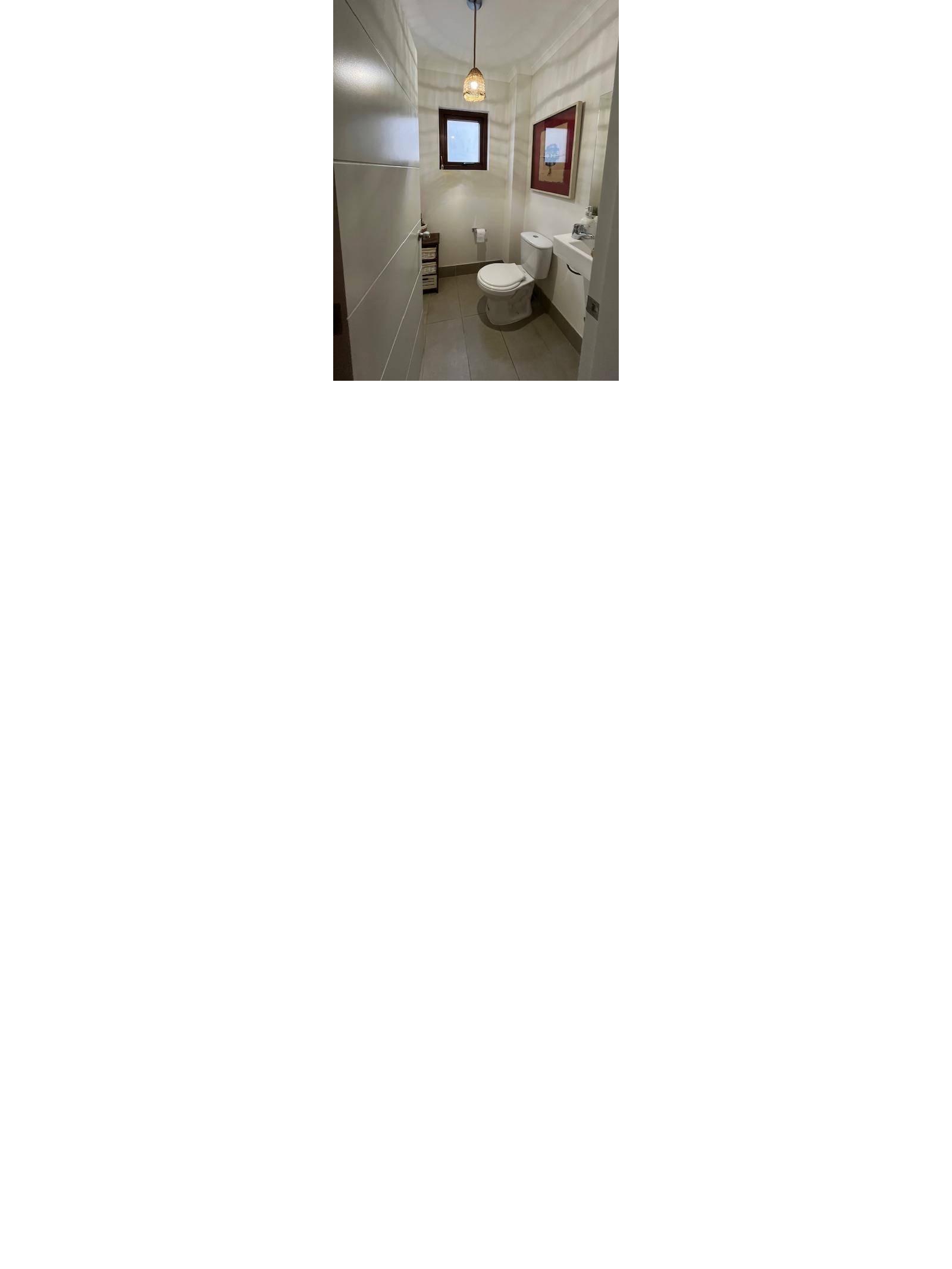Baño de visitas con sanitario y pequeña ventana alta
