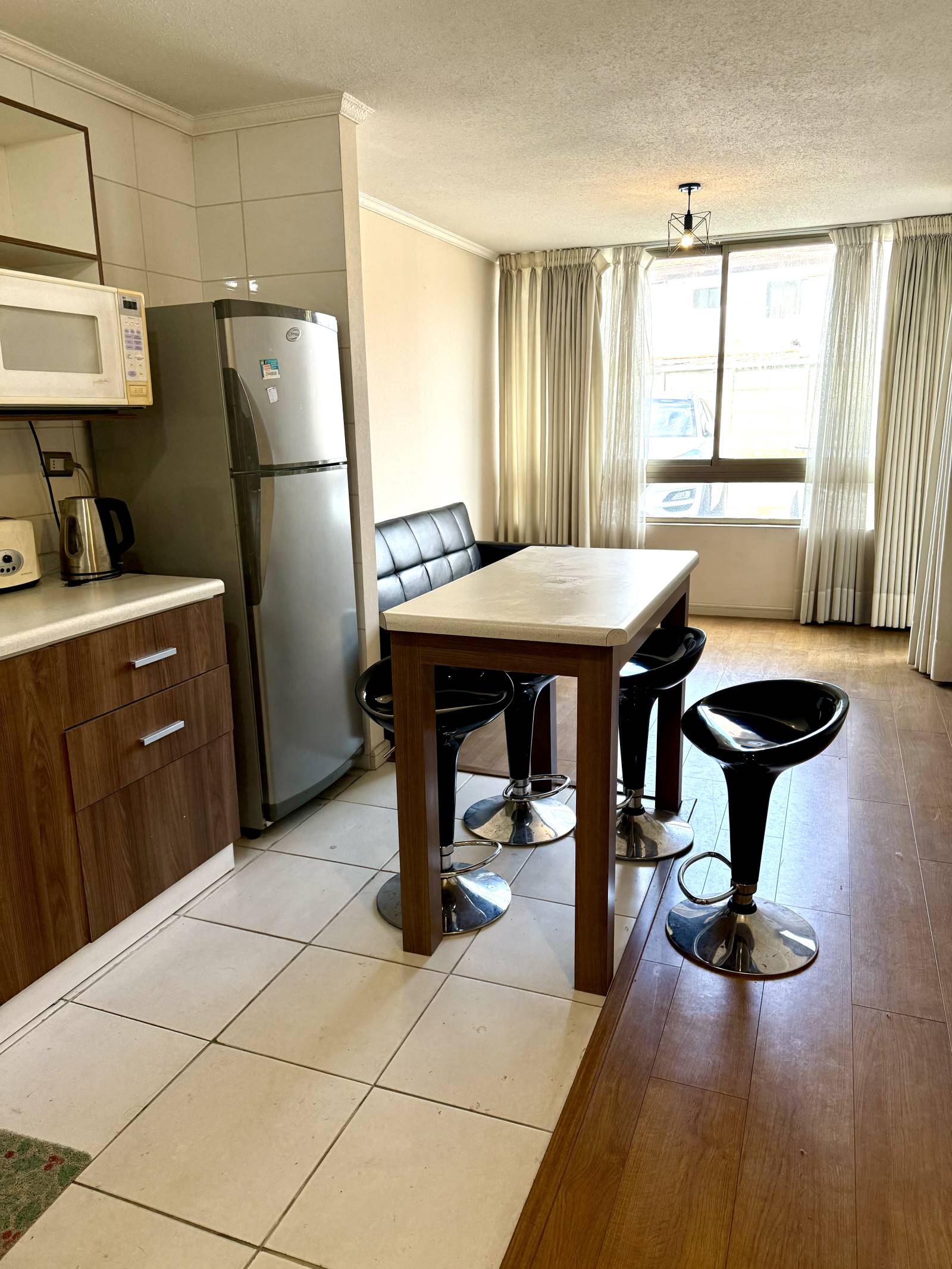 Comedor de diario junto a cocina con refrigerador y muebles