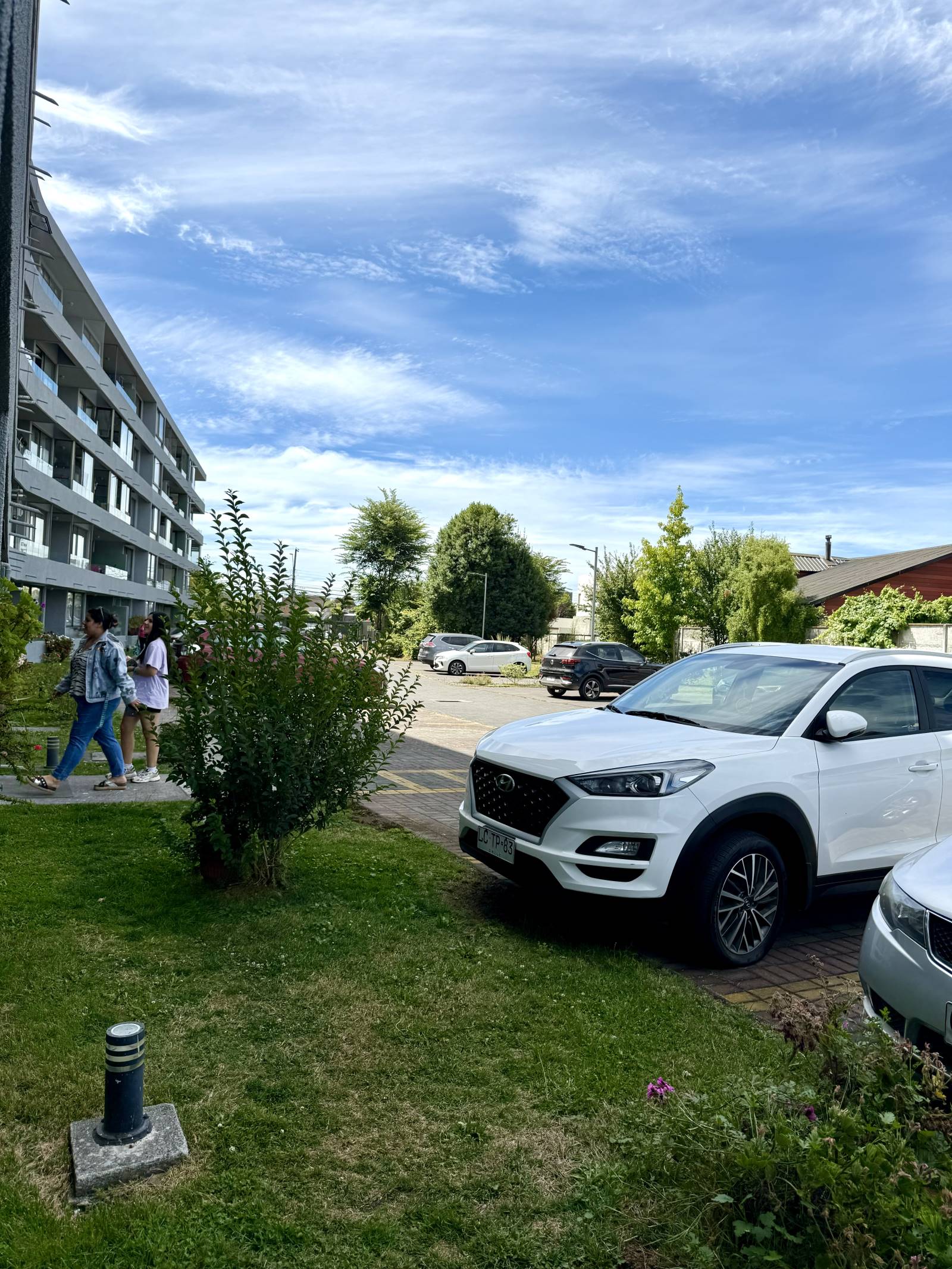 Áreas verdes y estacionamiento exterior del condominio