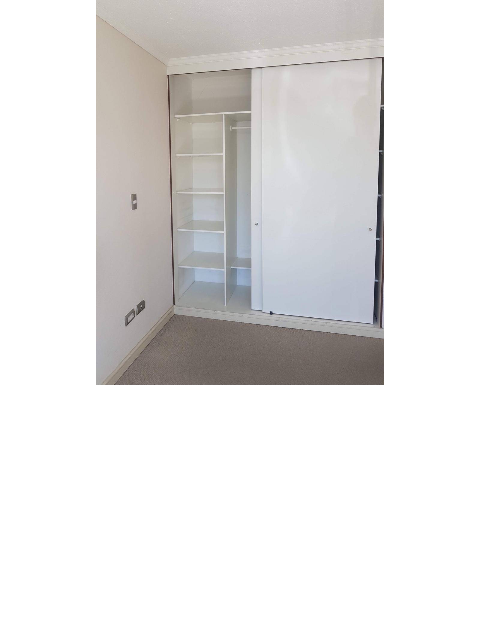 Dormitorio con amplio clóset blanco de puertas correderas