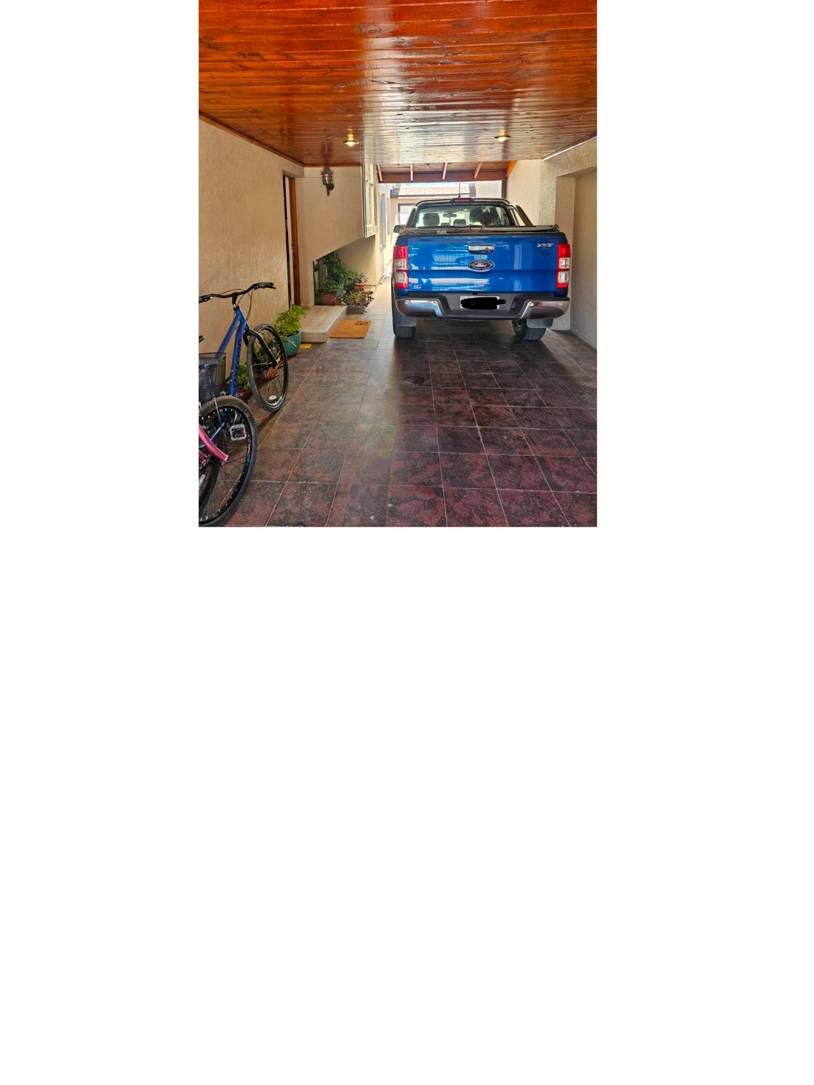 Estacionamiento techado con camioneta y piso cerámico