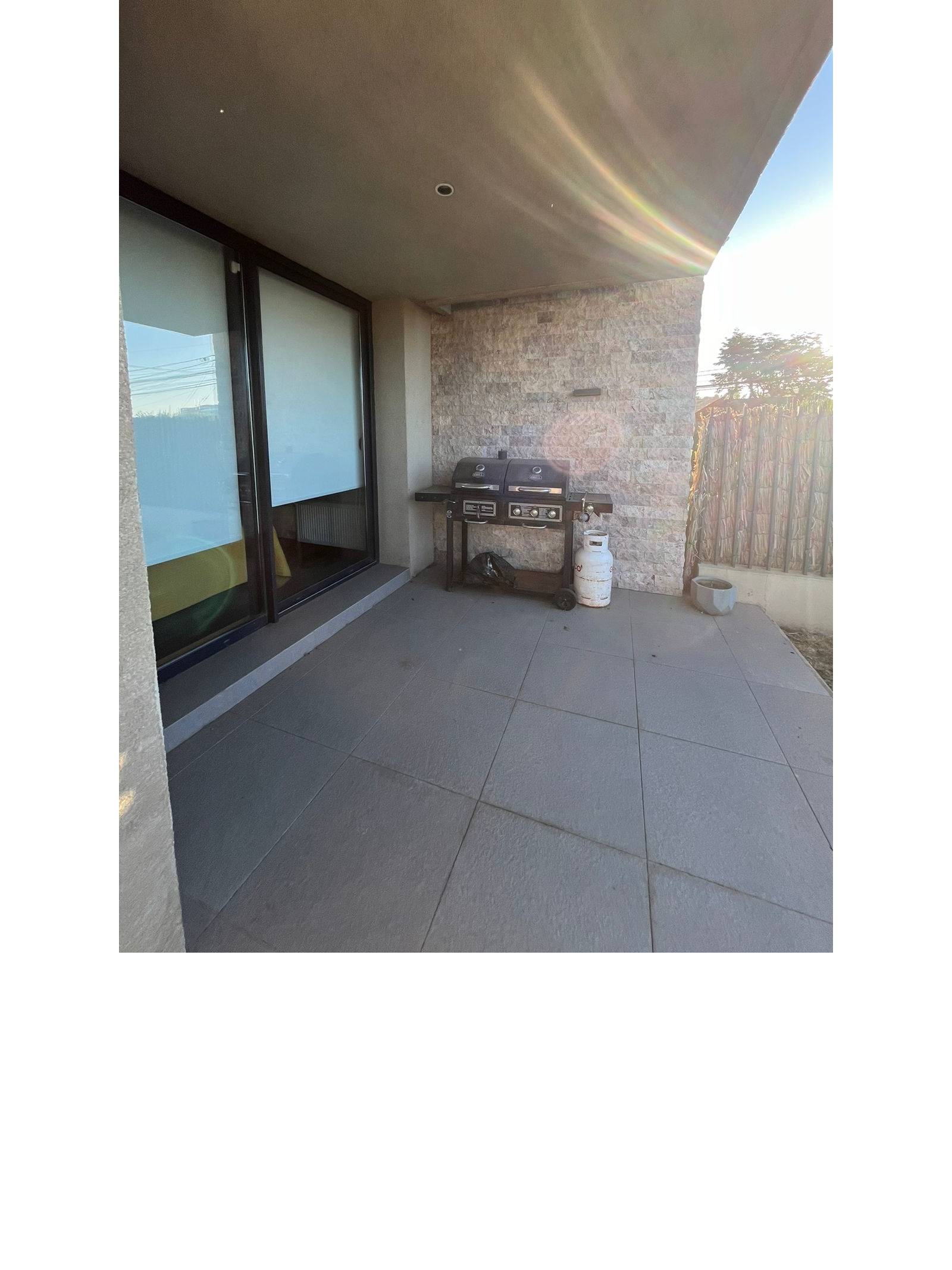 Terraza techada con parrilla a gas y piso cerámico