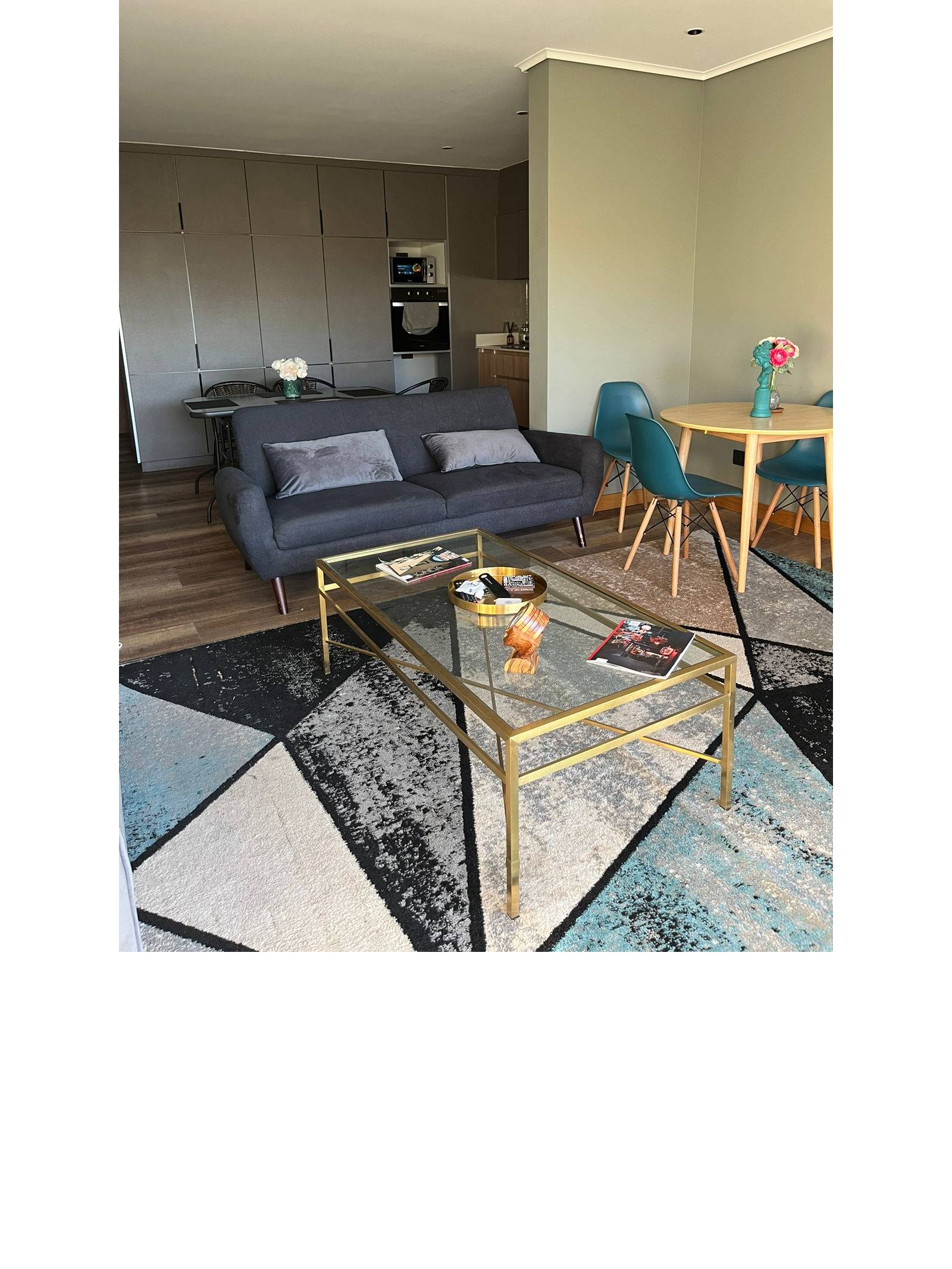 Living amoblado con sofá gris y mesa de centro metálica