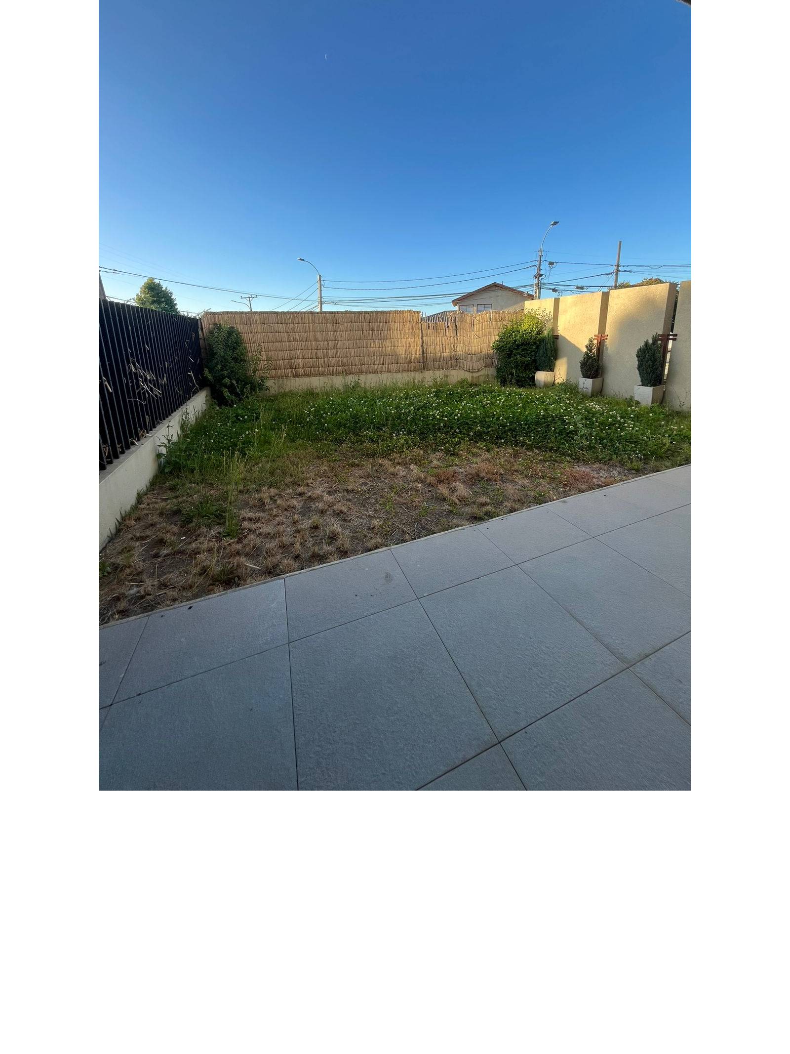 Patio privado cercado con área de césped y terraza
