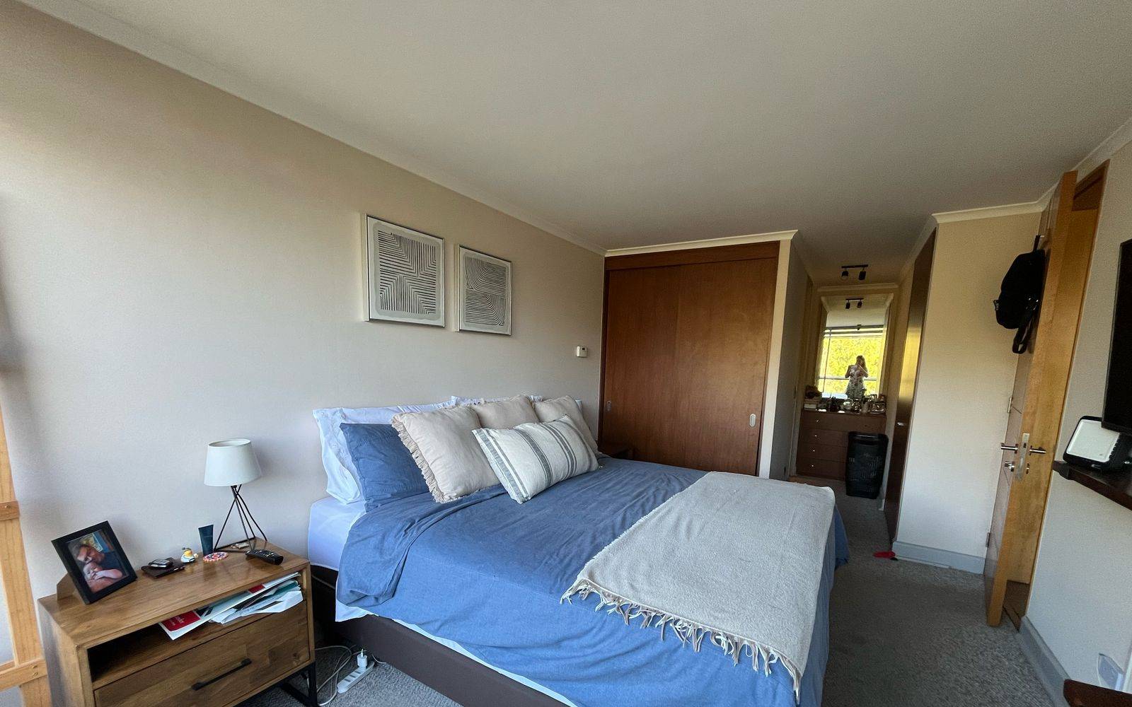 Dormitorio con cama de dos plazas, velador y clóset empotrado.