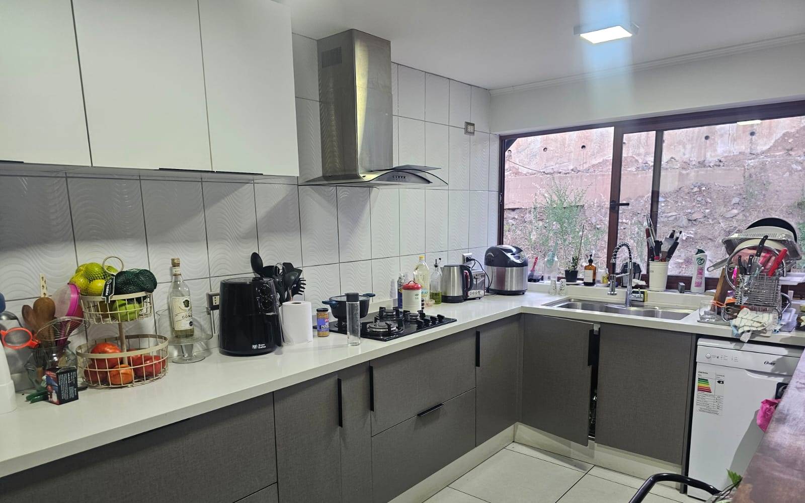 Cocina equipada con muebles modernos y encimera integrada.