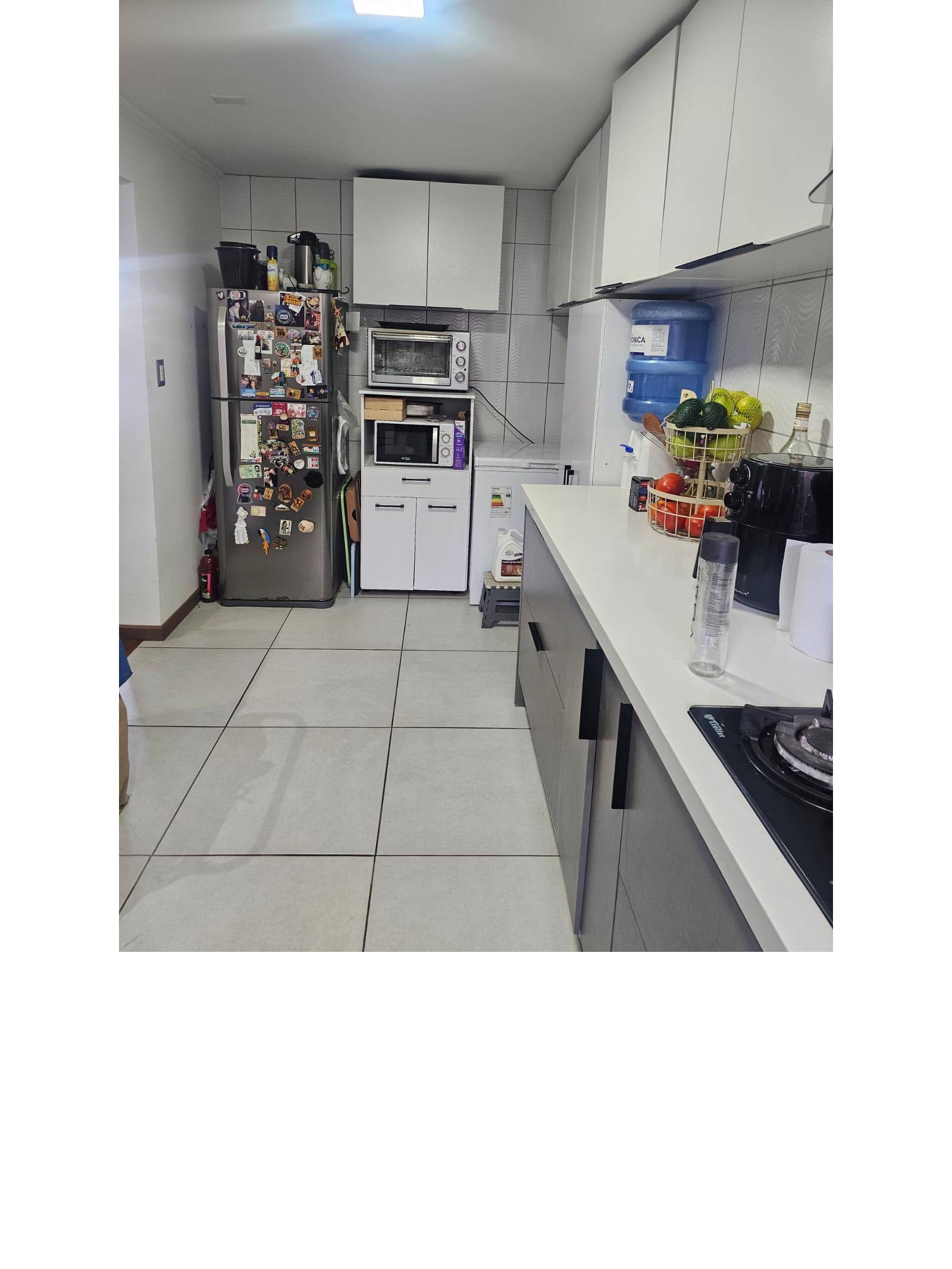 Área de refrigerador y despensa en cocina.