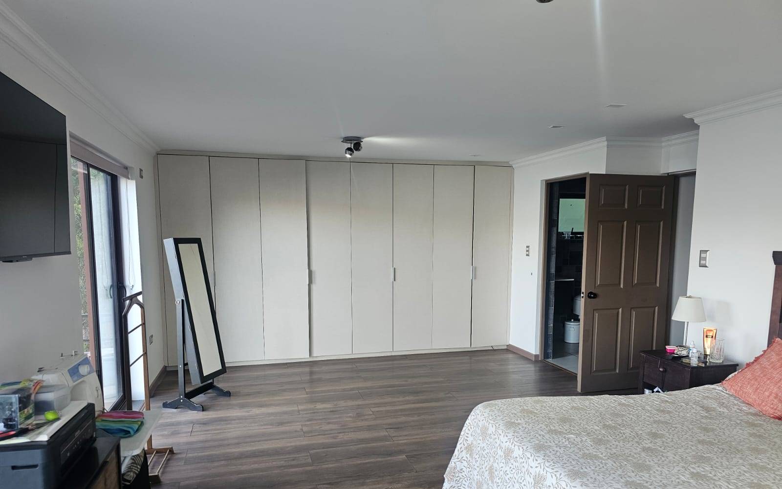 Dormitorio principal con closet de pared completa.