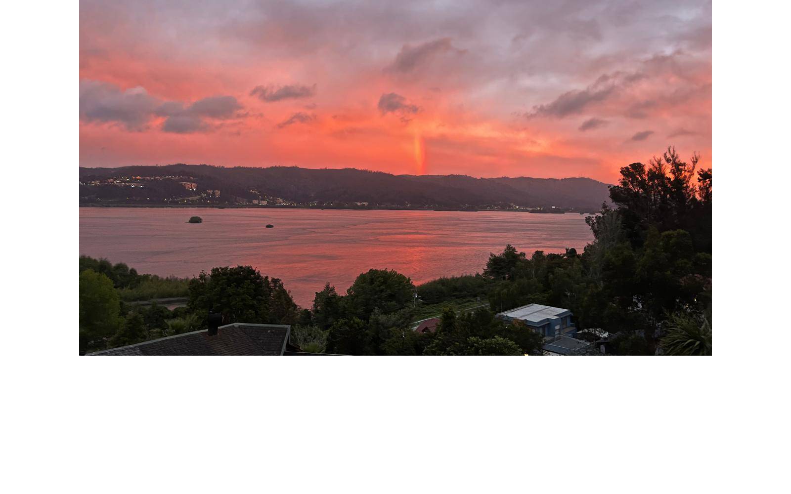 Atardecer con tonos rojizos sobre el río y cerros.