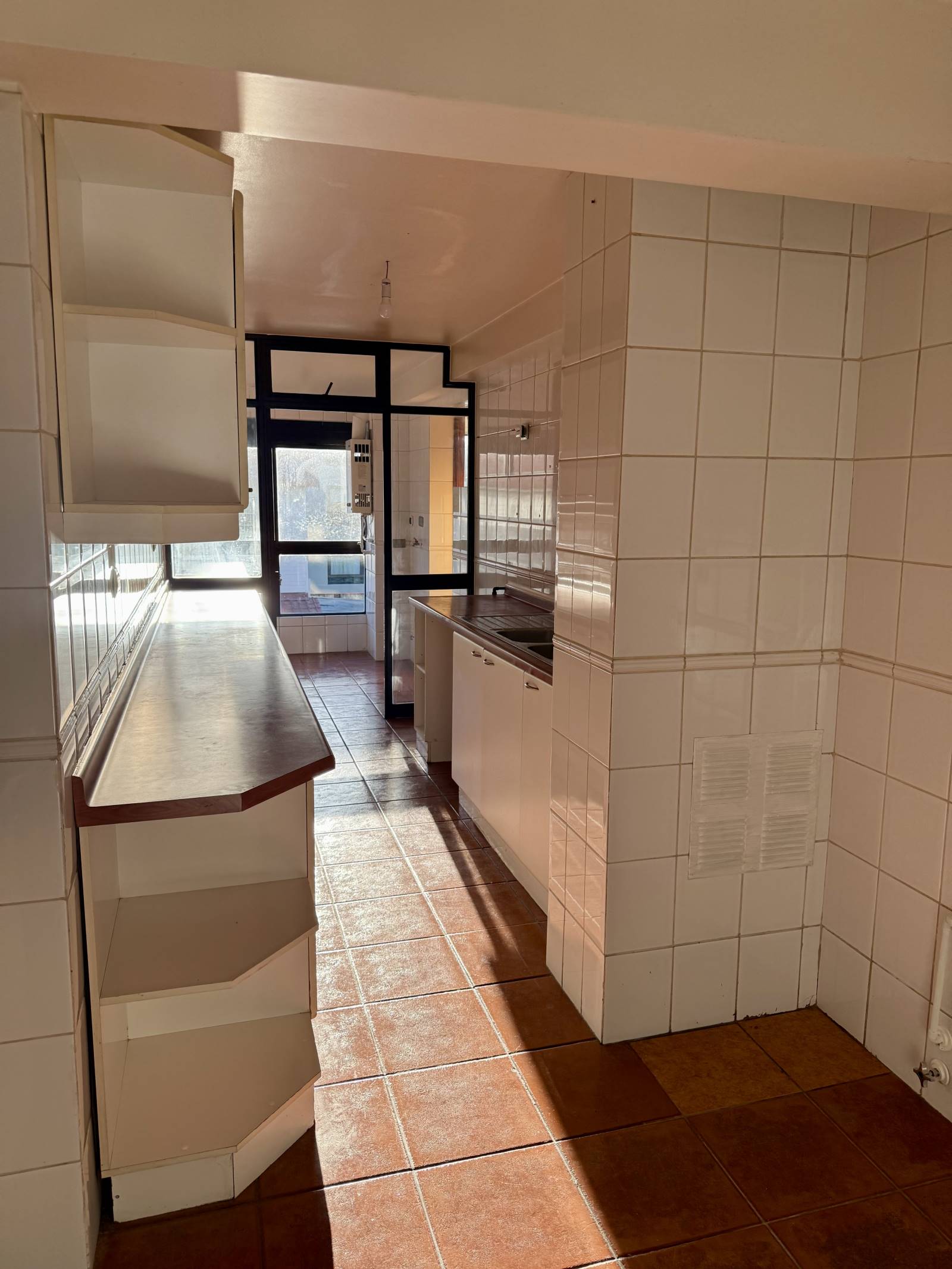 Cocina con muebles empotrados y piso cerámico