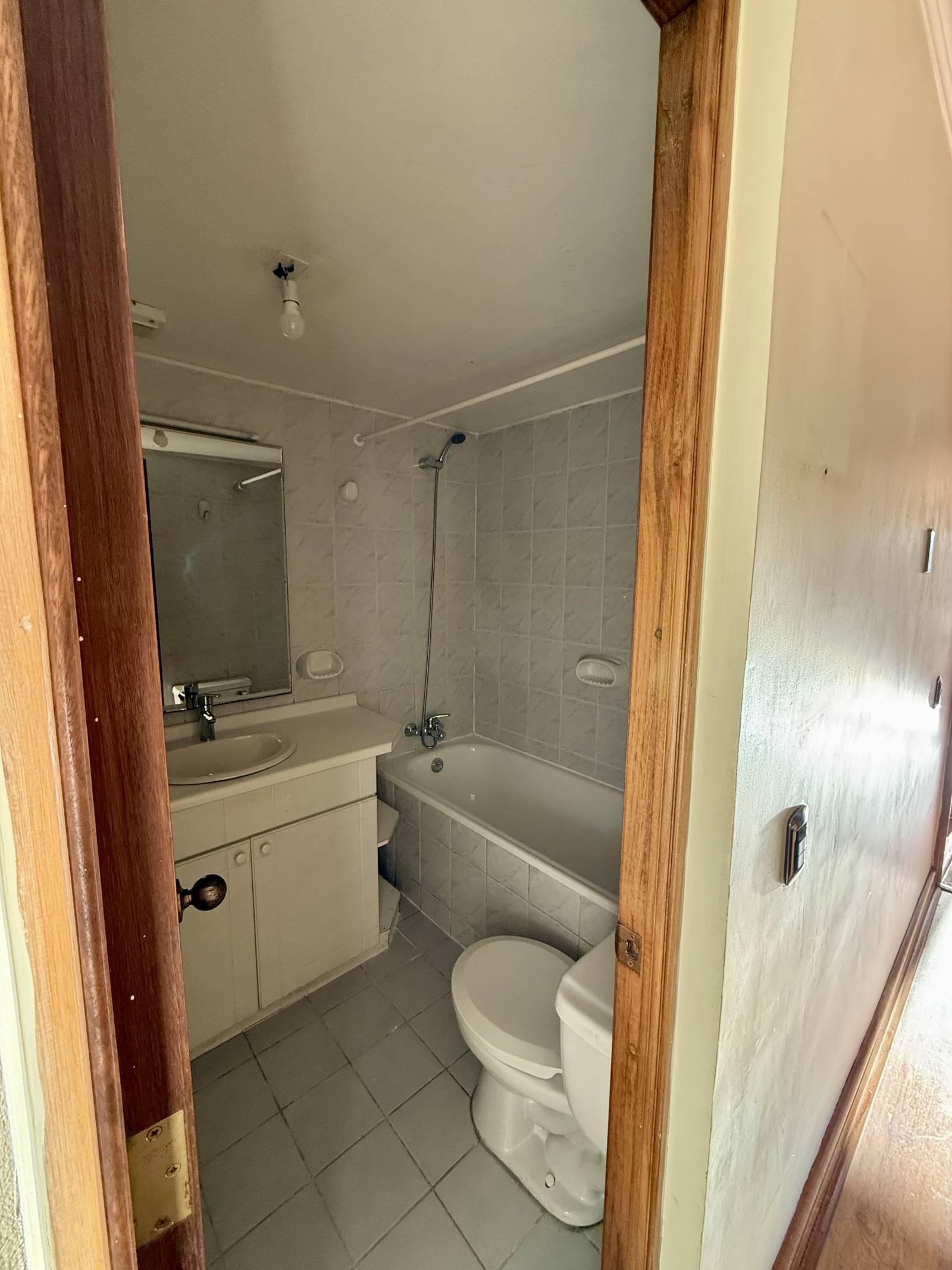 Baño completo con tina, vanitorio y muros cerámicos