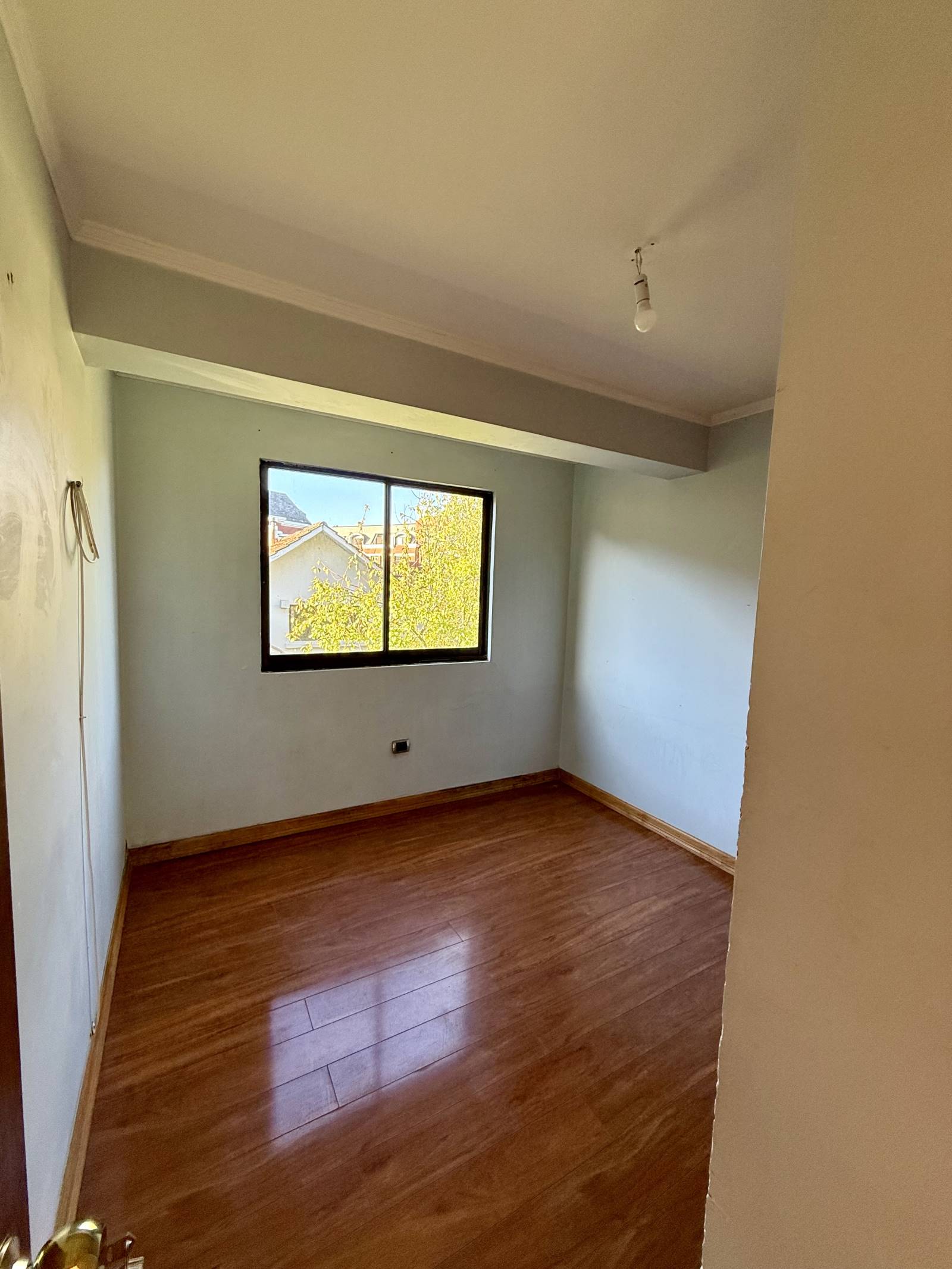 Dormitorio secundario con piso flotante y ventana